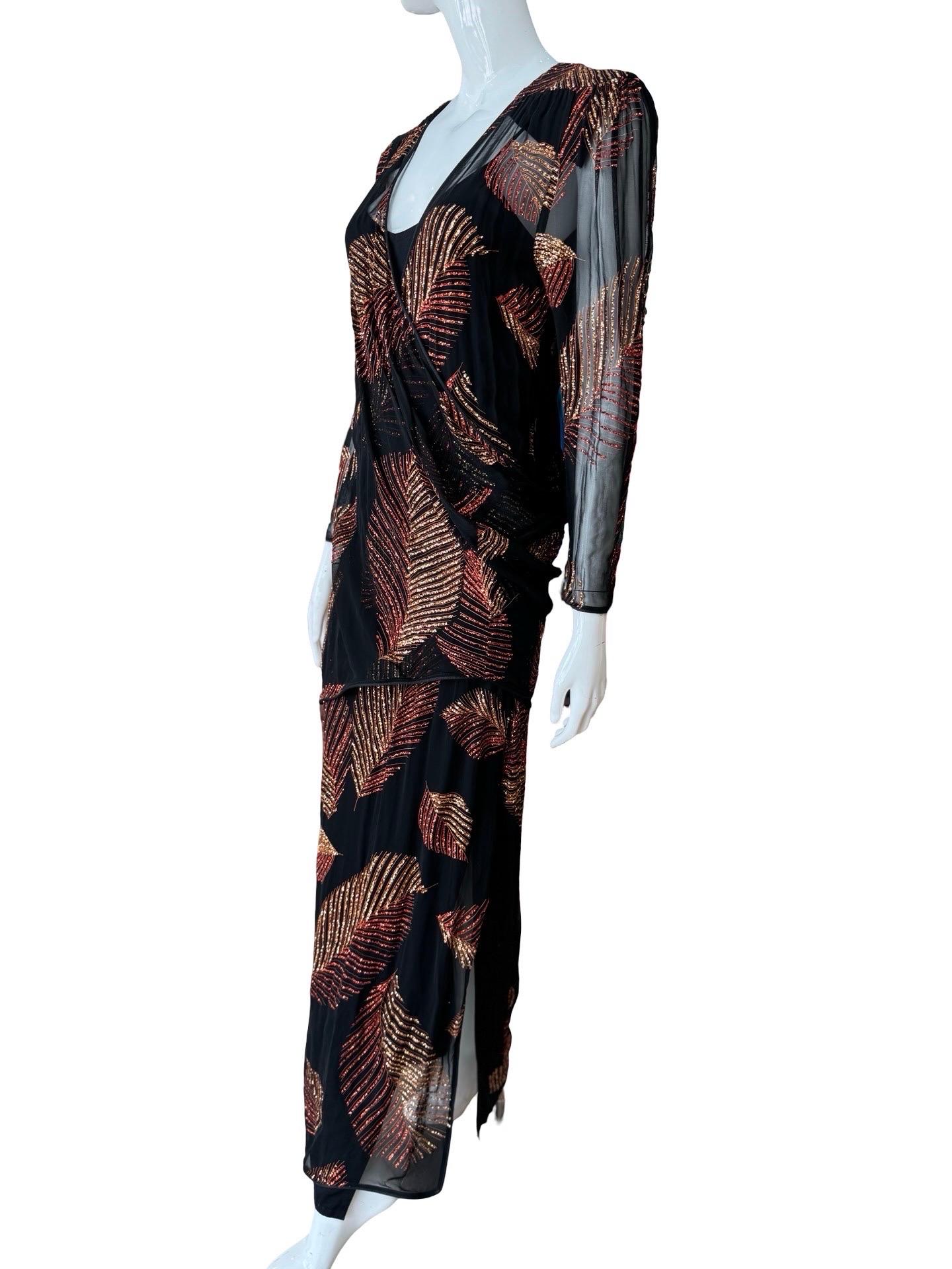 Toutes les vibrations disco de cette robe de Frank Usher.   Robe noire transparente avec manches.  Le tissu transparent est recouvert d'un motif de feuilles pailletées de couleur rouge et bronze.  La robe est presque enveloppante, avec un tissu