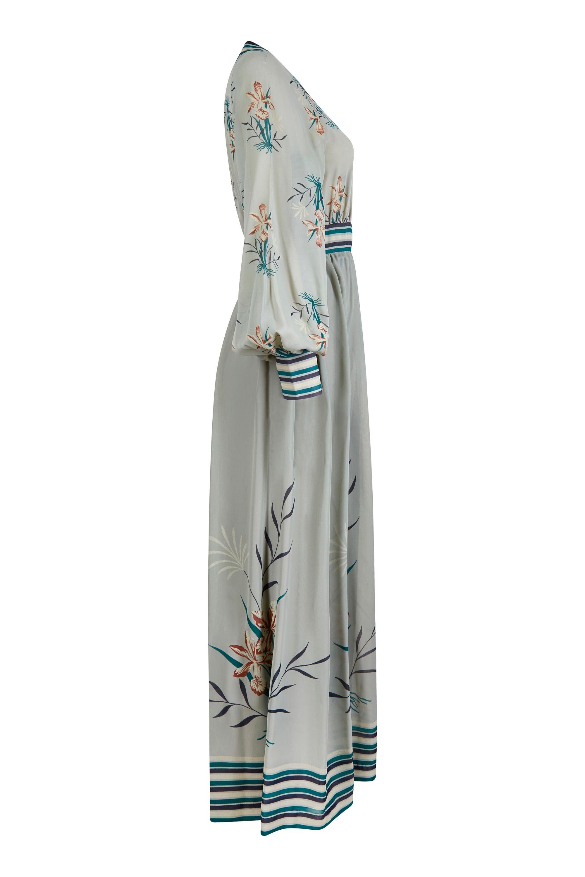 This beautiful 1970s Frank Usher printed chiffon maxi dress in seafoam green is elegant, feminine, and in excellent vintage condition. The dress features a wrap over bodice which is secured across the bust with concealed hook and eye fastenings to