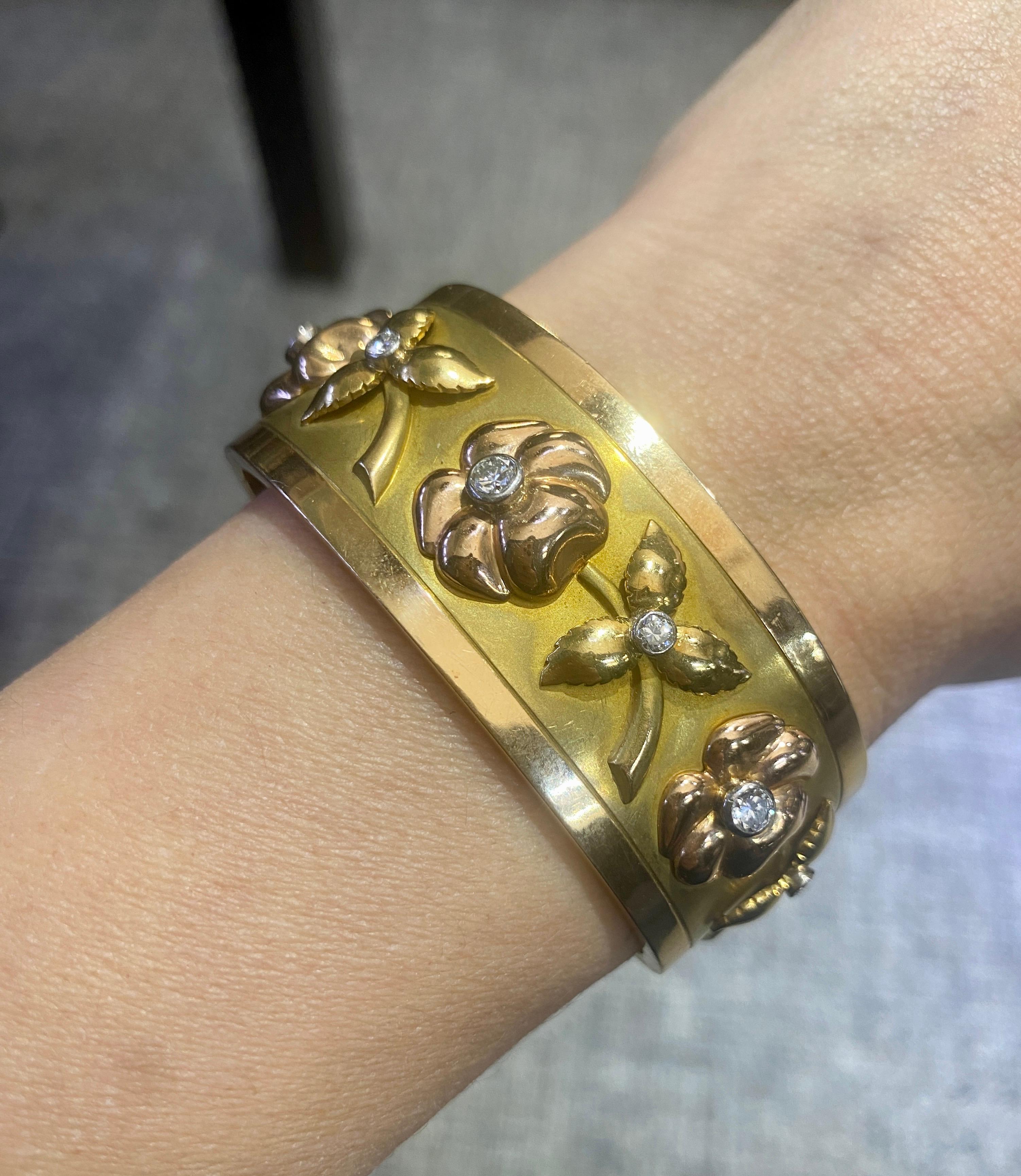 This stunning 1970s French 18 k gold bangle is beautifully made from yellow and rose gold. The design consists of alternating flower and leaf patterns in yellow and rose gold with a round diamond at the center of each. 

The bangle is a wonderfully