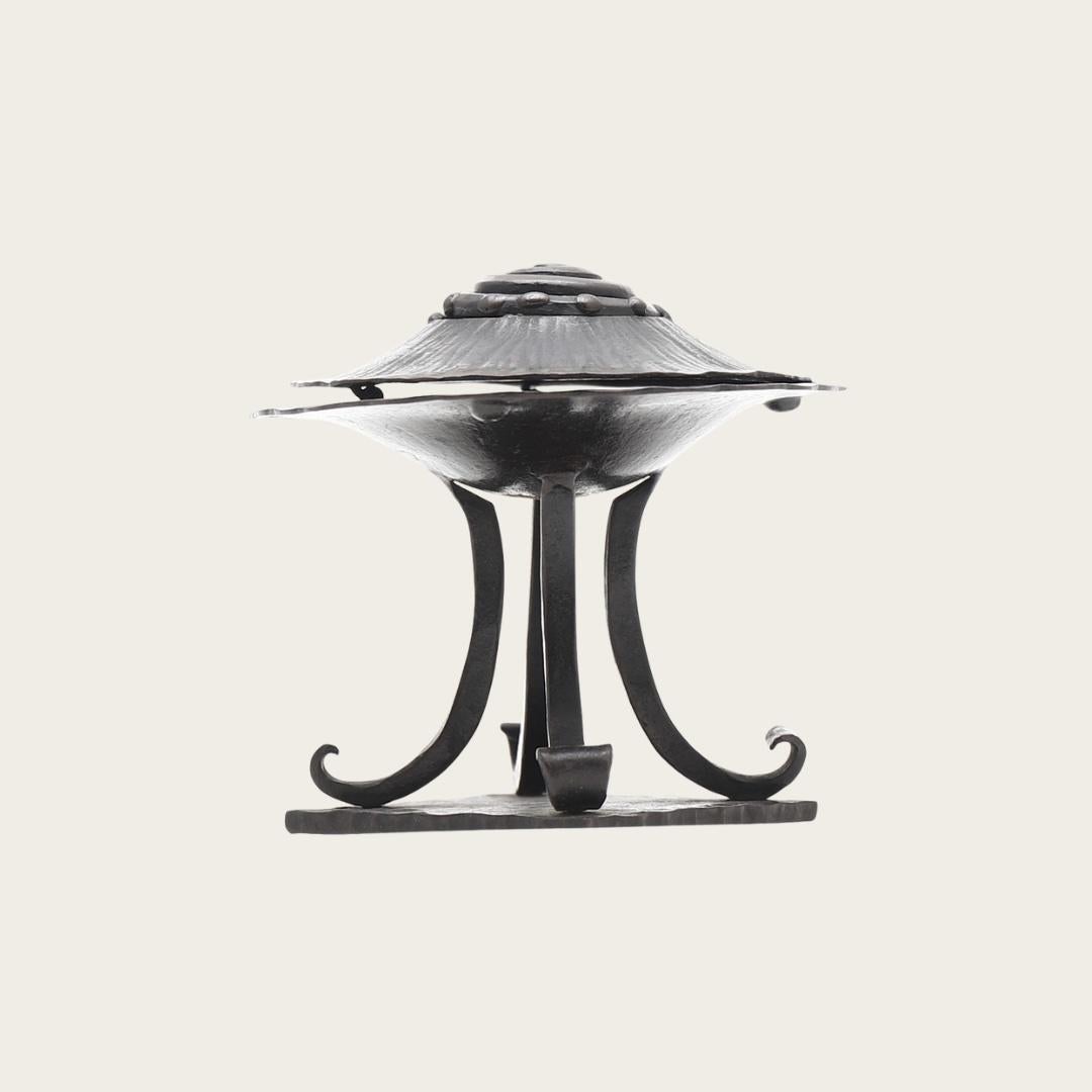 Featuring a nautilus spiral design on the lid and curved legs, this incense burner is marked 