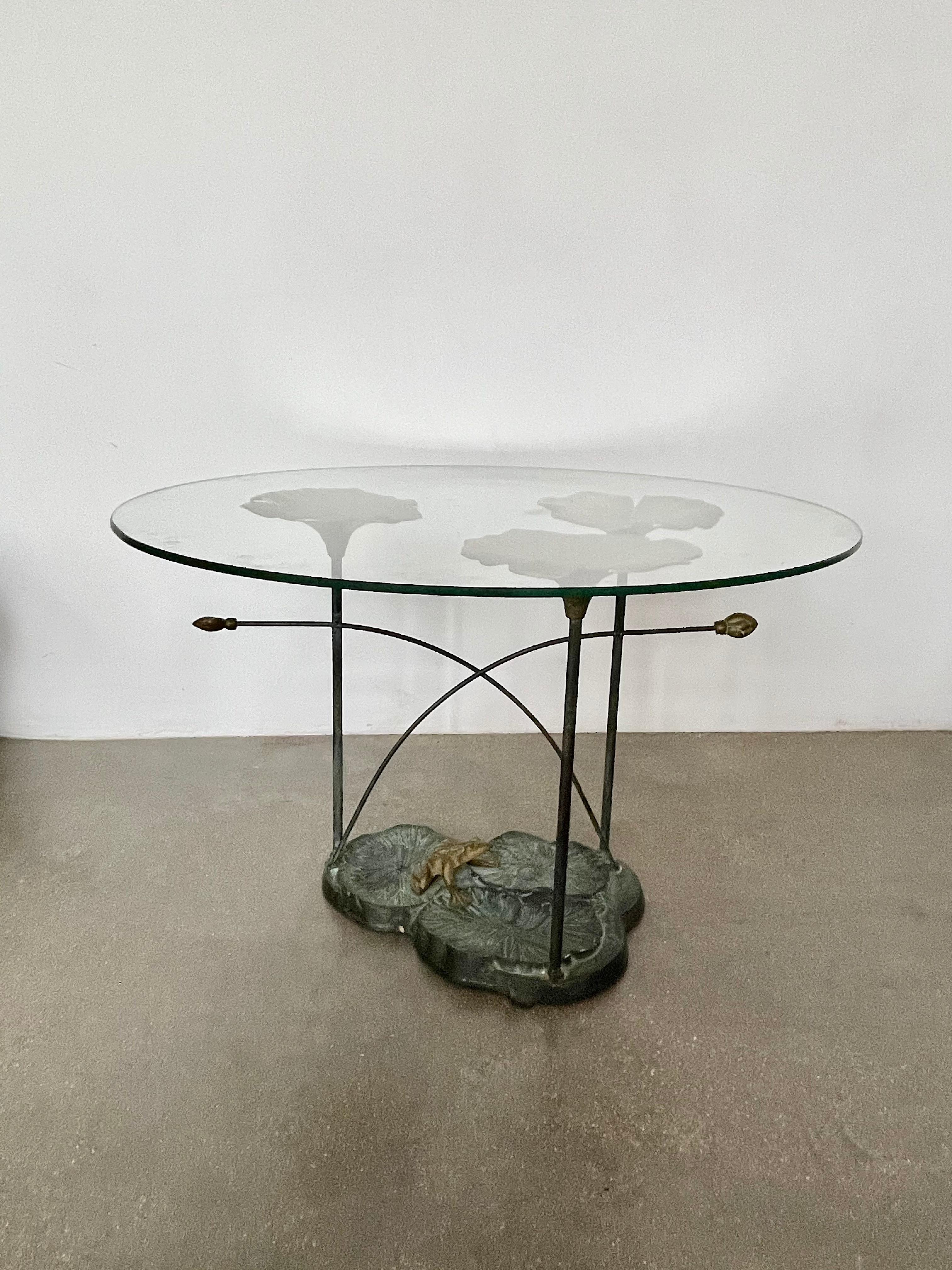 A fantastic 20th-century vintage coffee table handcrafted out of bronze and glass. The structure is designed with intricate gold flower shapes and an organic earth-like base. The round tabletop is made out of clear glass. 

------

We are an