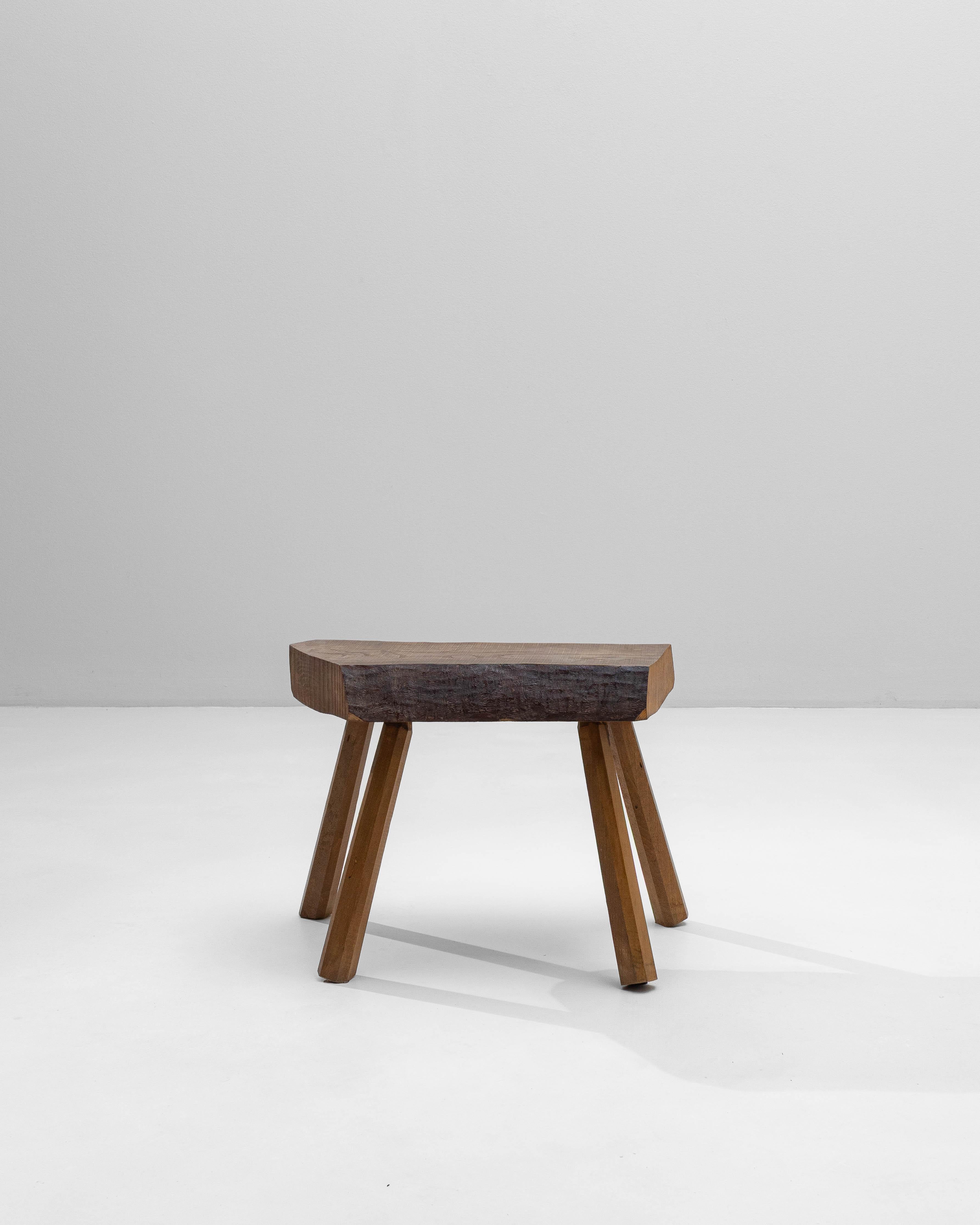 This 1970s French Brutalist wooden stool exemplifies the movement’s emphasis on raw materials and honest construction. Built from a thick, hand-hewn slab seat, the piece highlights the natural grain and texture of the wood, with visible tool marks