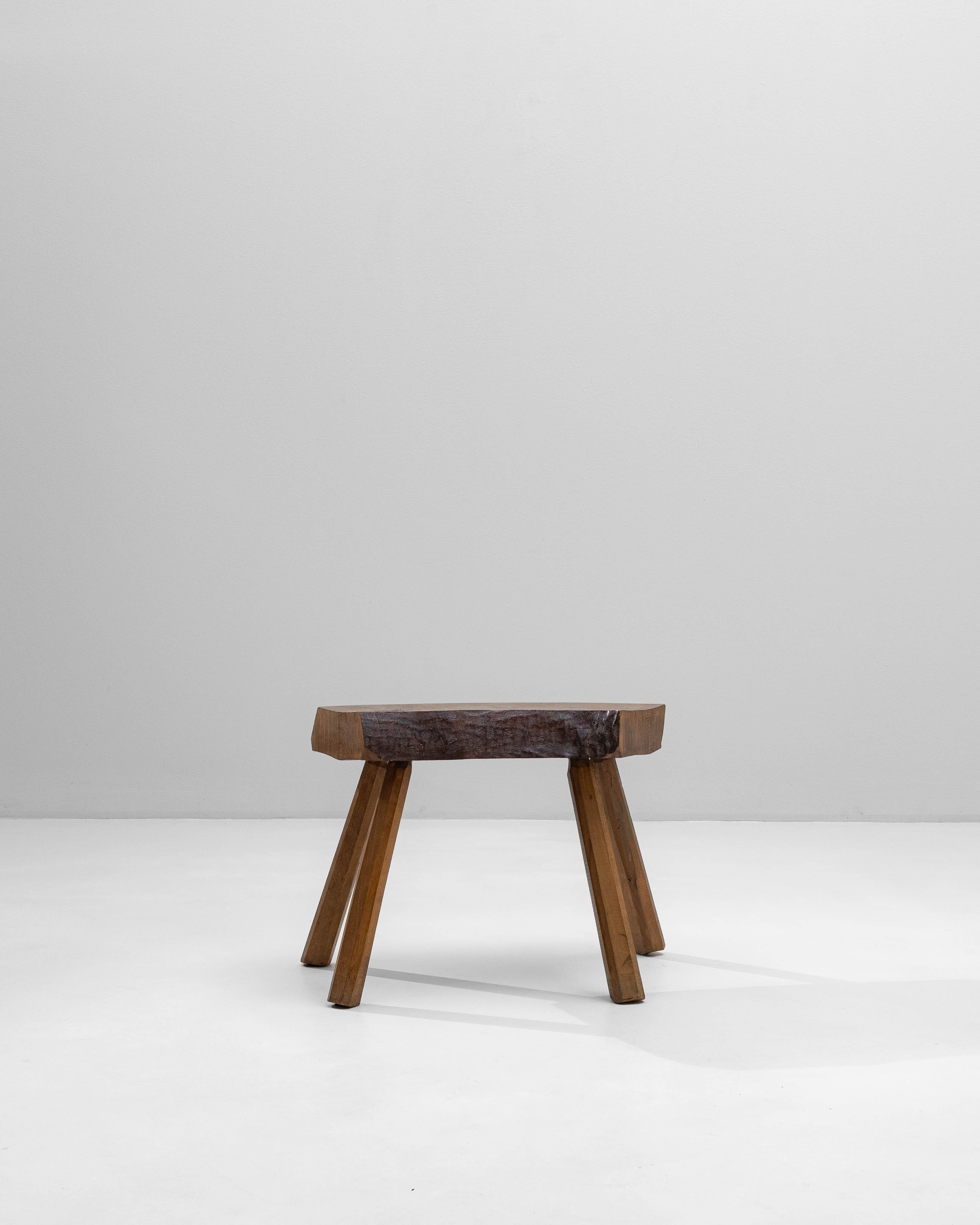 This 1970s French Brutalist wooden stool showcases the movement’s hallmark dedication to raw, expressive craftsmanship. Its thick, irregularly carved seat retains a strikingly tactile surface, revealing chisel marks and natural variations that