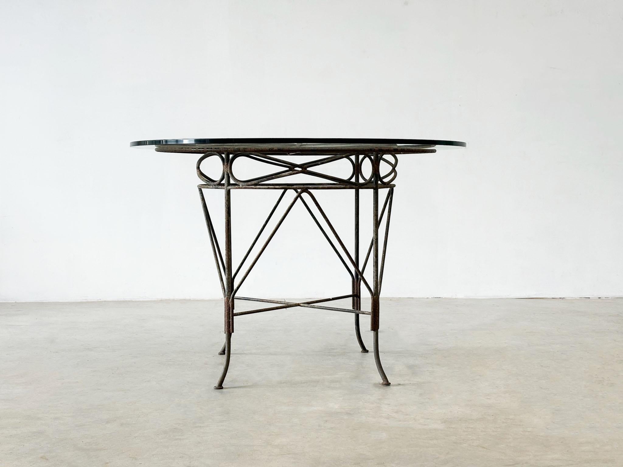 Mesa de comedor de exterior francesa de hierro fundido de los años 70
Esta mesa de exterior de los años 70, probablemente fabricada en Francia, tiene una estructura de hierro fundido y un tablero de cristal. Su diseño muestra bellas formas