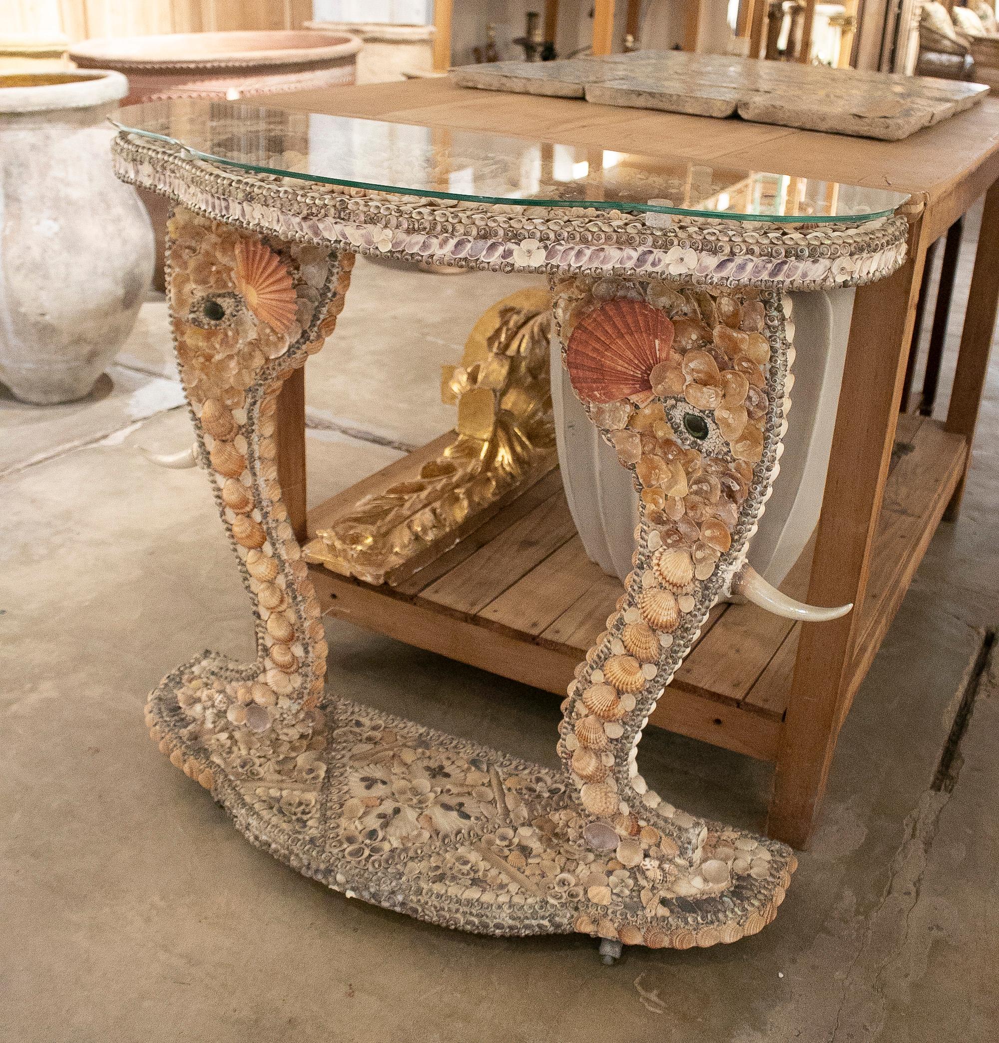 Vintage 1970s French conch studded console table with elephant head shaped head and glass top.