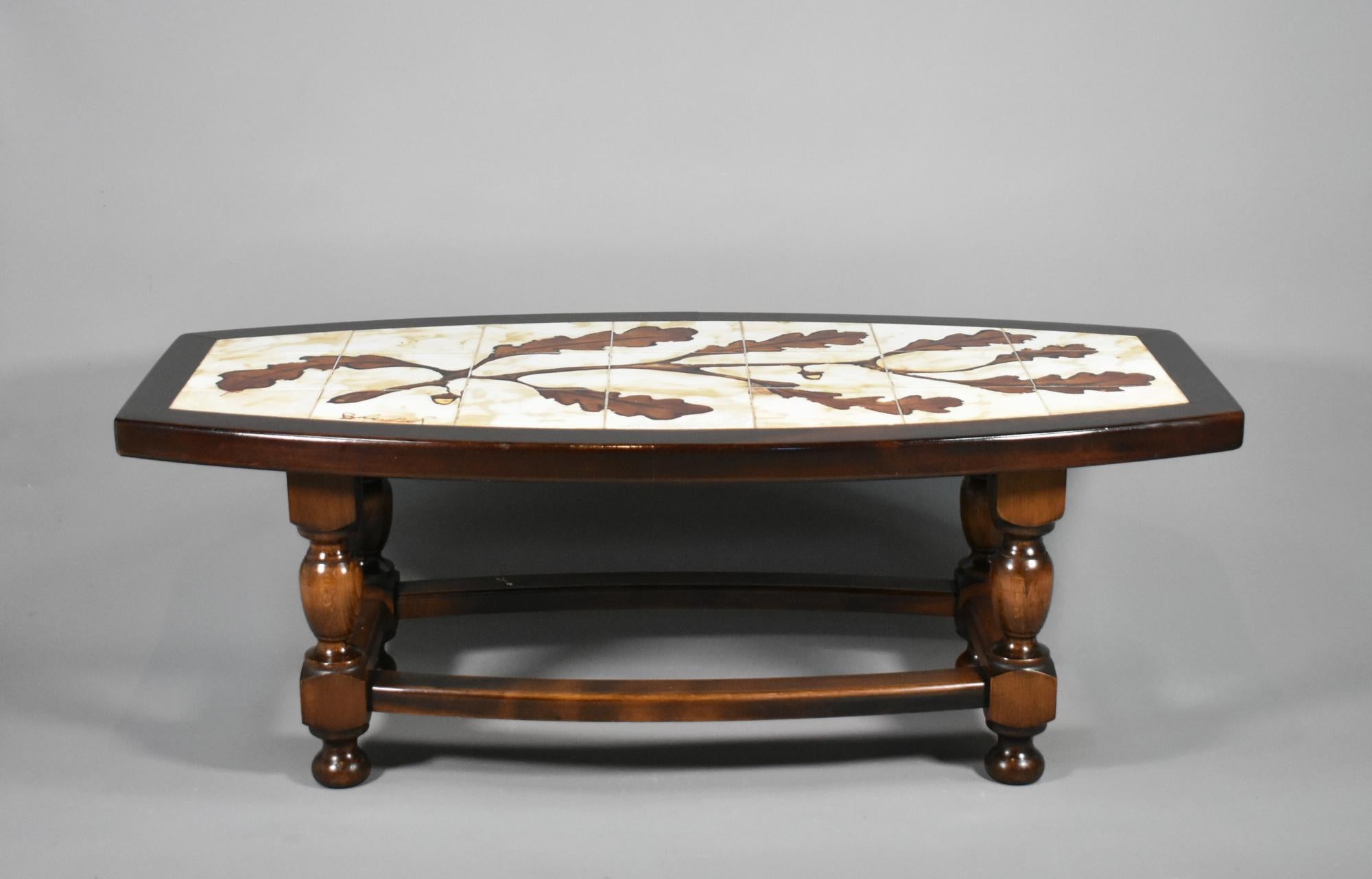 1970s French Designer Coffee Table with Tiled Signed Top
 
This classically designed coffee table features hand drawn oak leaves and acorns decorated in gloss finish over individually coloured earthenware tiles that are inset into a carved thick
