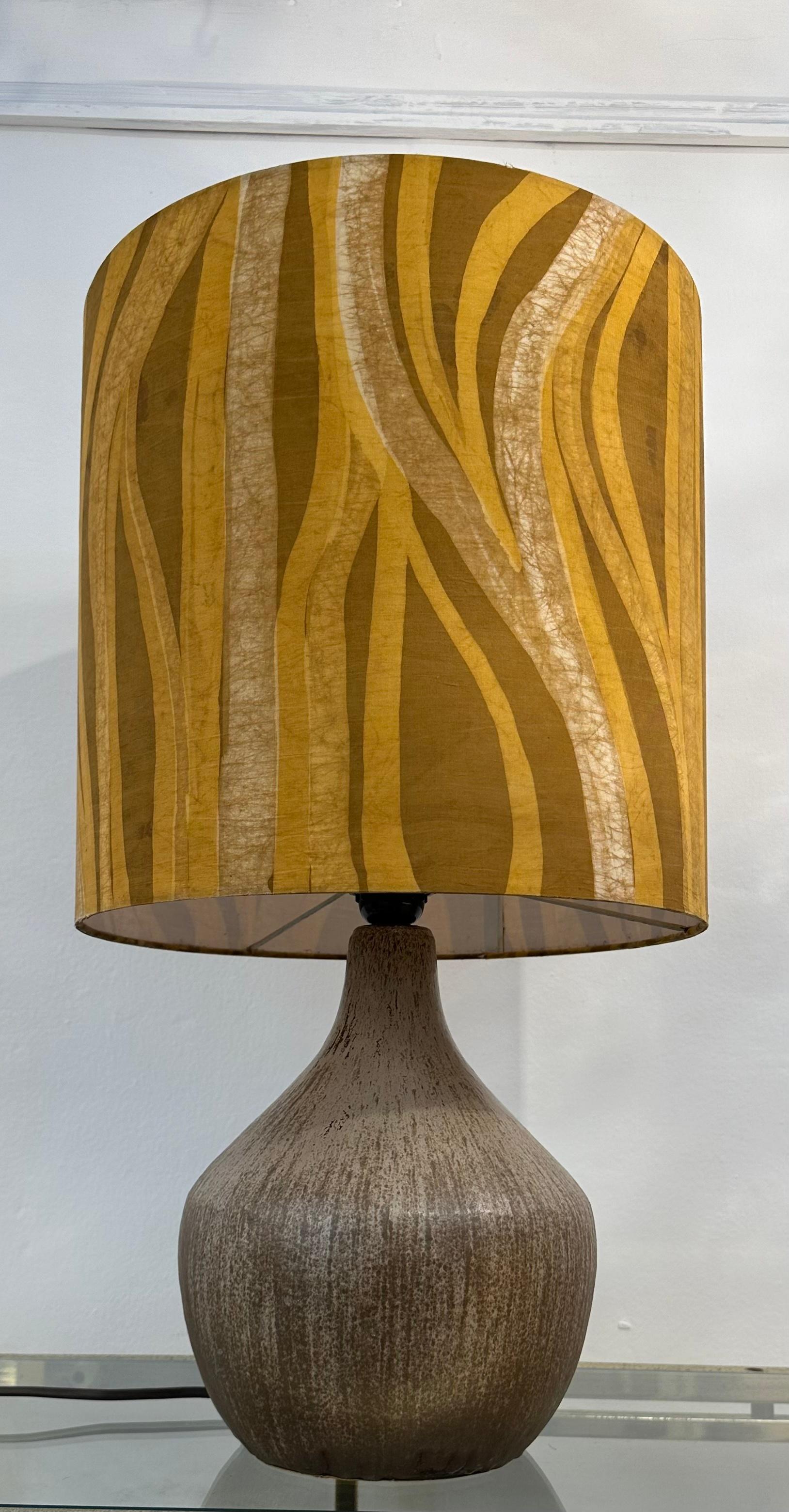 1970s French earthenware ceramic table lamp with its original unique shade. The lamp base is made of earthenware, which is a type of ceramic that is fired at a high temperature. This gives the lamp a durable and hardwearing finish. The matt glaze