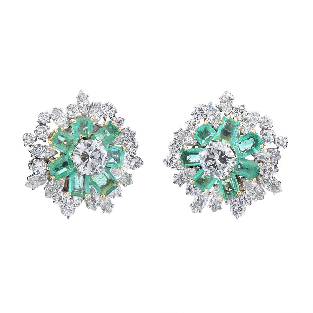 A brilliant cut diamond surrounded by a spray of emeralds and a further 24 diamonds, both marquise and brilliant cuts. All diamonds are mounted on white gold, while the emeralds rest upon a yellow gold setting. Central diamonds weighing a total of 3