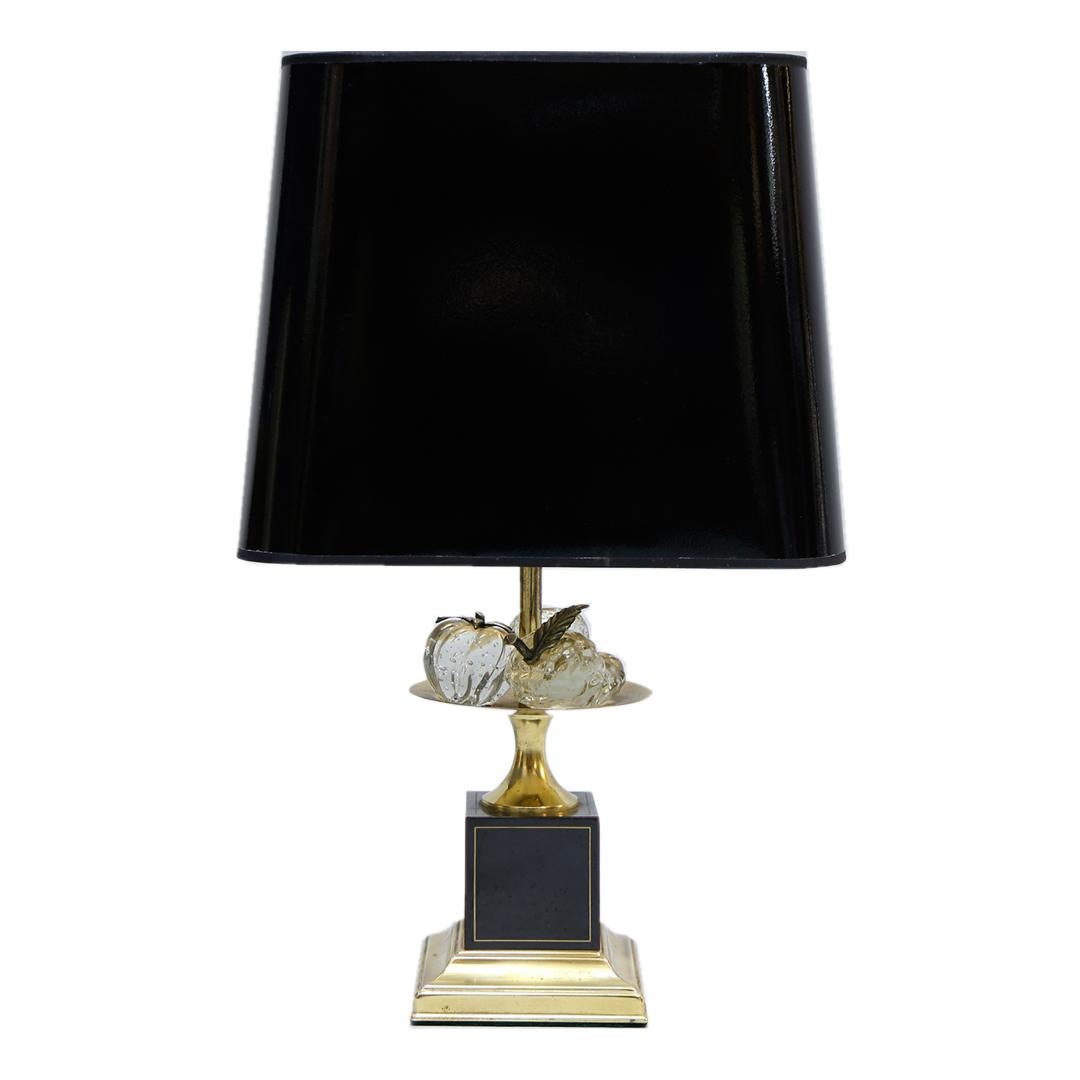 Rara Lámpara de Mesa con Frutero de Cristal, con un pie en metal dorado y lacado negro, rematado con un vaso lleno de 3 frutas de cristal de La Maison Le Dauphin Francia años 70 . 
Además de una iluminación de diseño que funciona bien, también es un