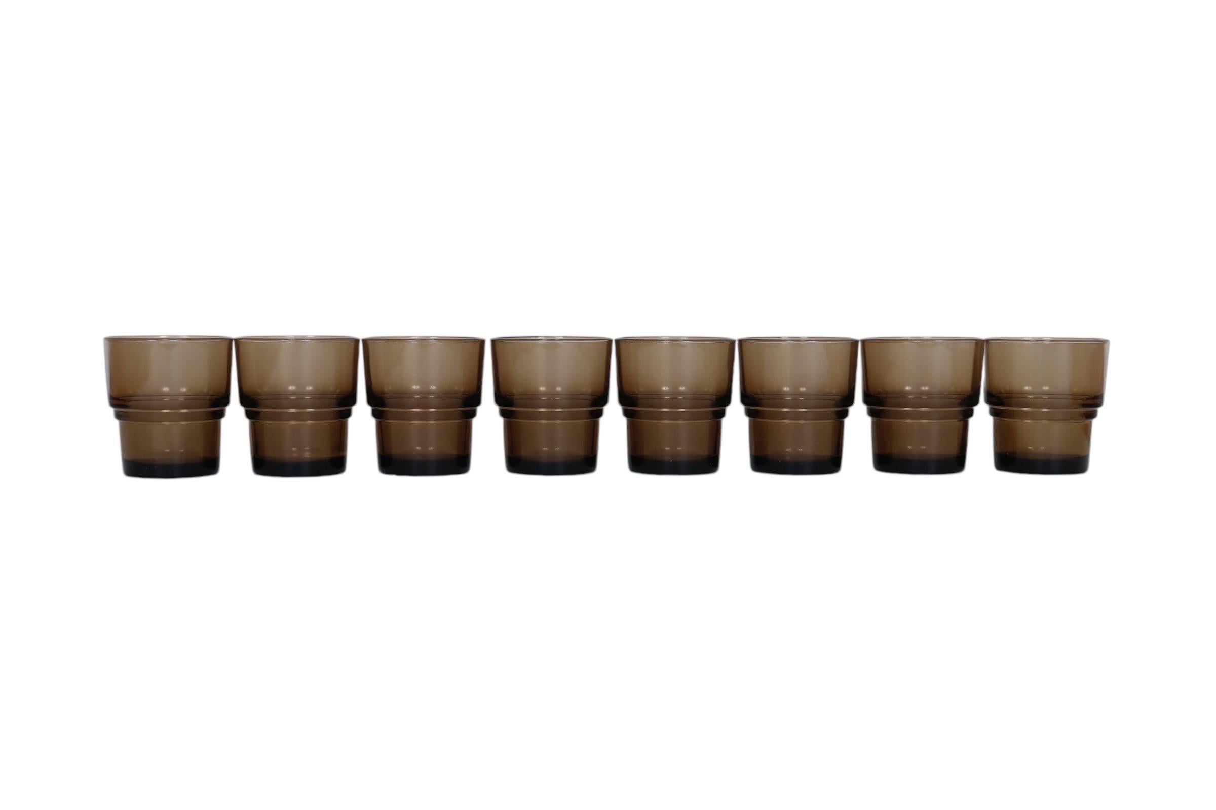 A set of eight French drinking glasses from the 1970’s, made by Vereco. Smoked glass is stepped halfway down making them easily stacked. Marked ‘Vereco France’ underneath.

