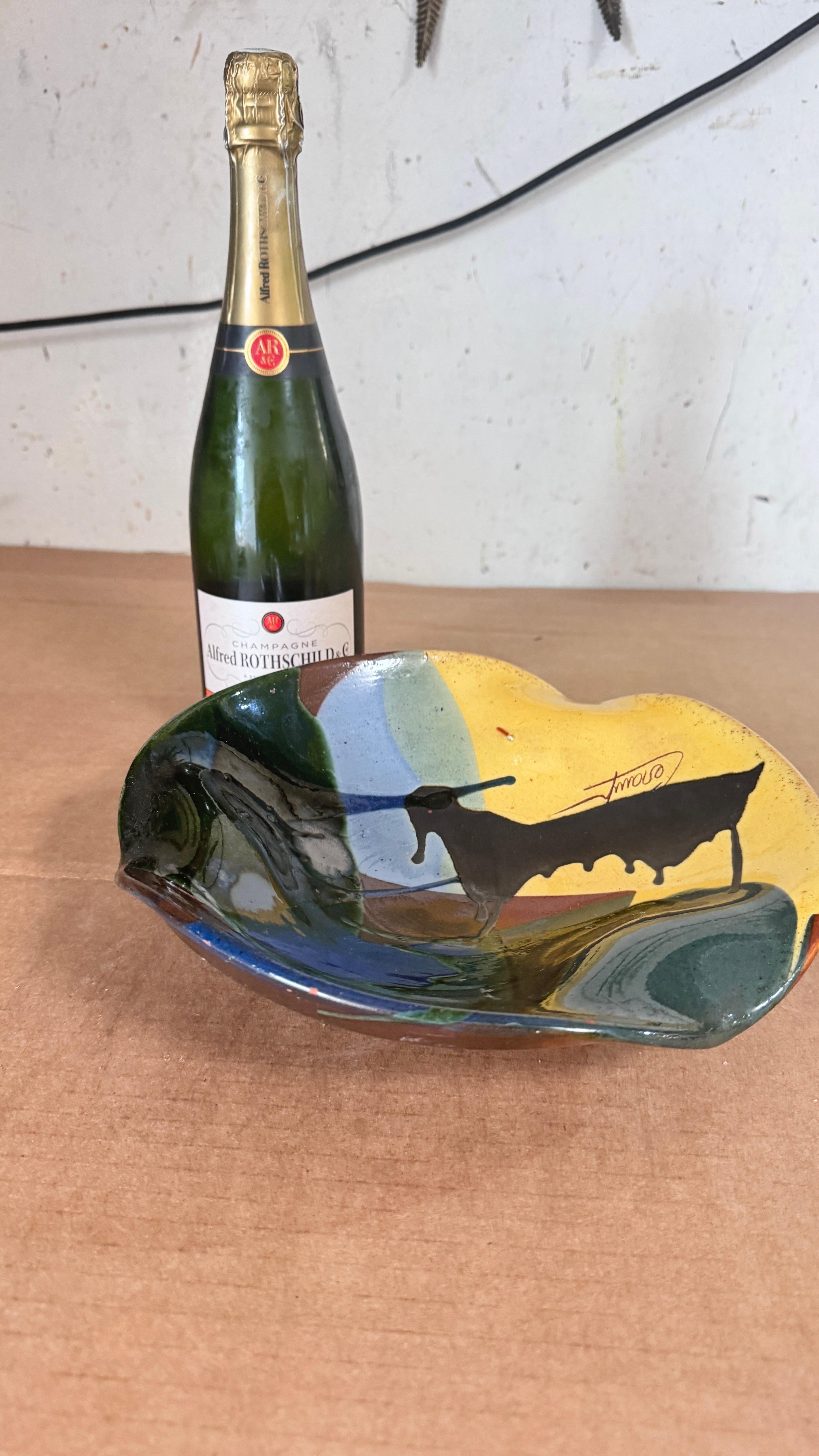 Description:
This striking glazed pottery platter, crafted in France in the 1970s, features a bold and expressive black bull at its center, surrounded by vibrant accents of yellow, green, and blue. Reminiscent of the work of southern French