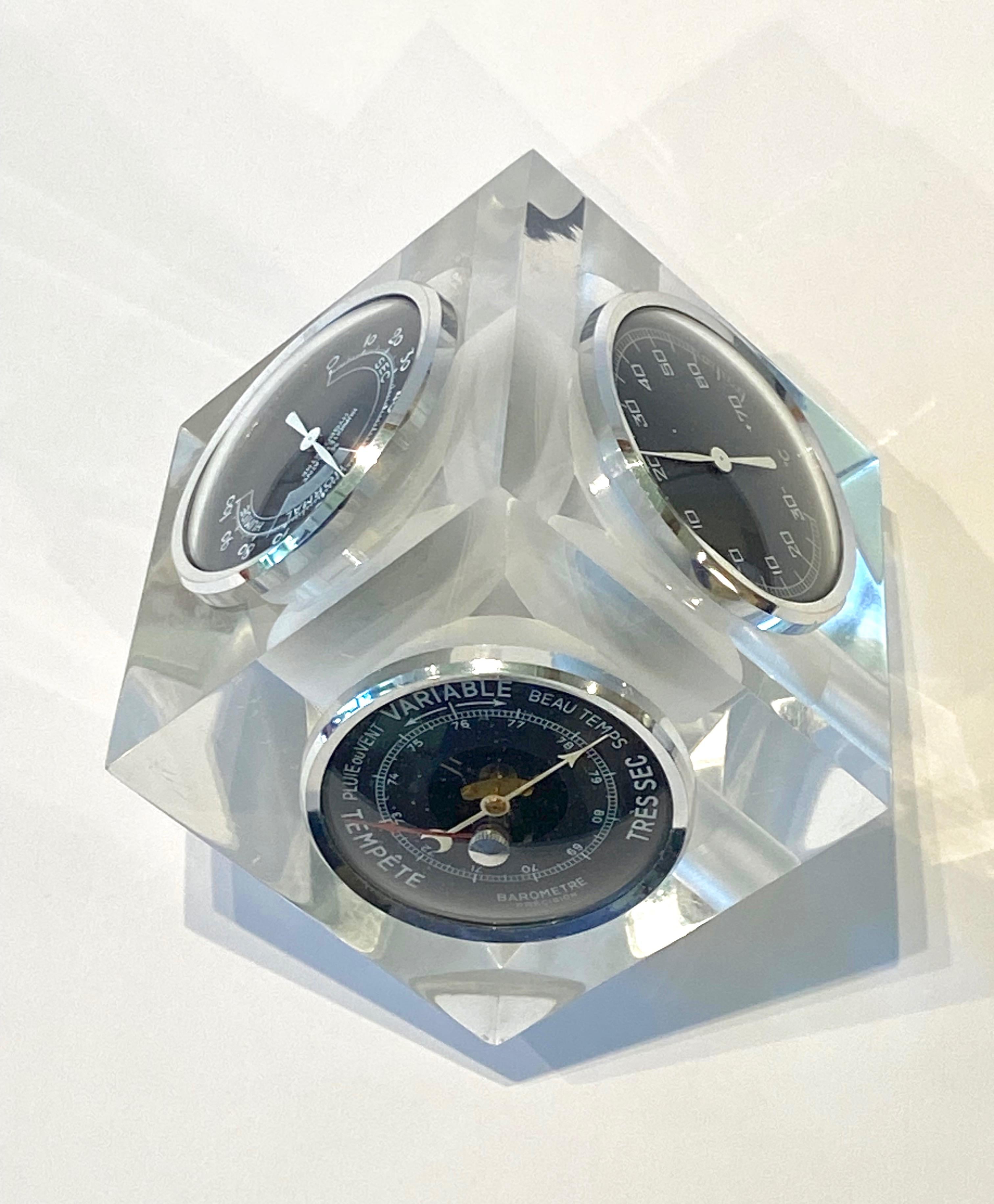 1970s French lucite cube desk top weather station, the faceted cube is three sided with three instruments with one corner of the cube cut to create an angle to make it face upwards. The three instruments are a barometre (barometric pressure gauge),