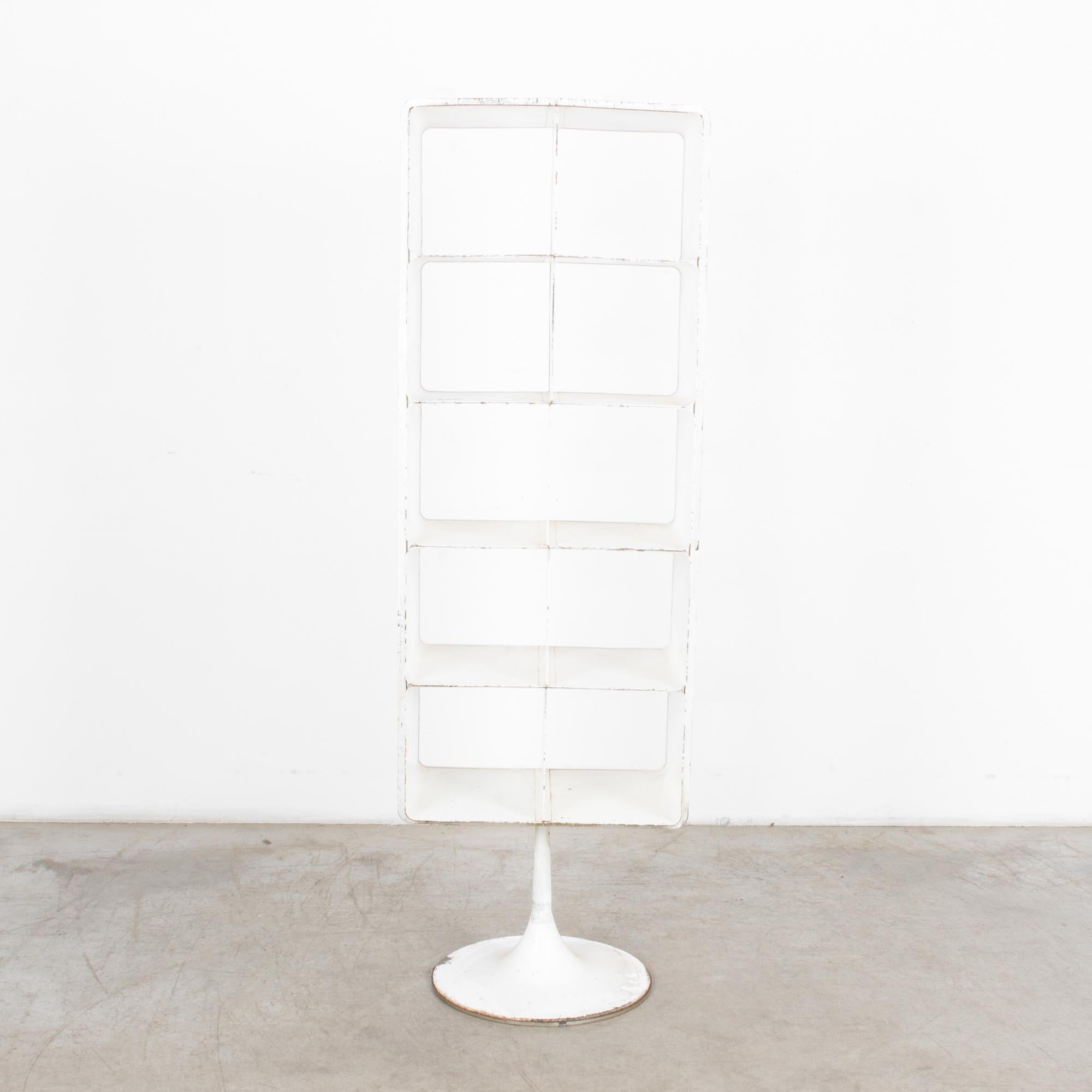 This metal shelf was made in France, circa 1970. Painted white, areas near the edges reveal the metal beneath. Supported on a stand with a circular base, this retro and stylish bookcase features two columns with five shelves to display your books,