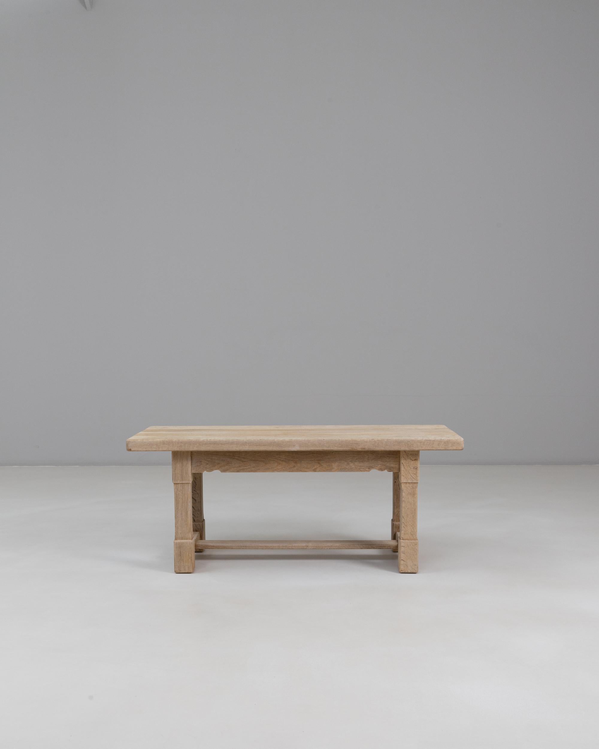 This 1970s French oak coffee table offers a clean, understated aesthetic rooted in traditional craftsmanship. The rectangular top showcases the natural character of the oak, with visible grain patterns and a softly worn surface that adds warmth and