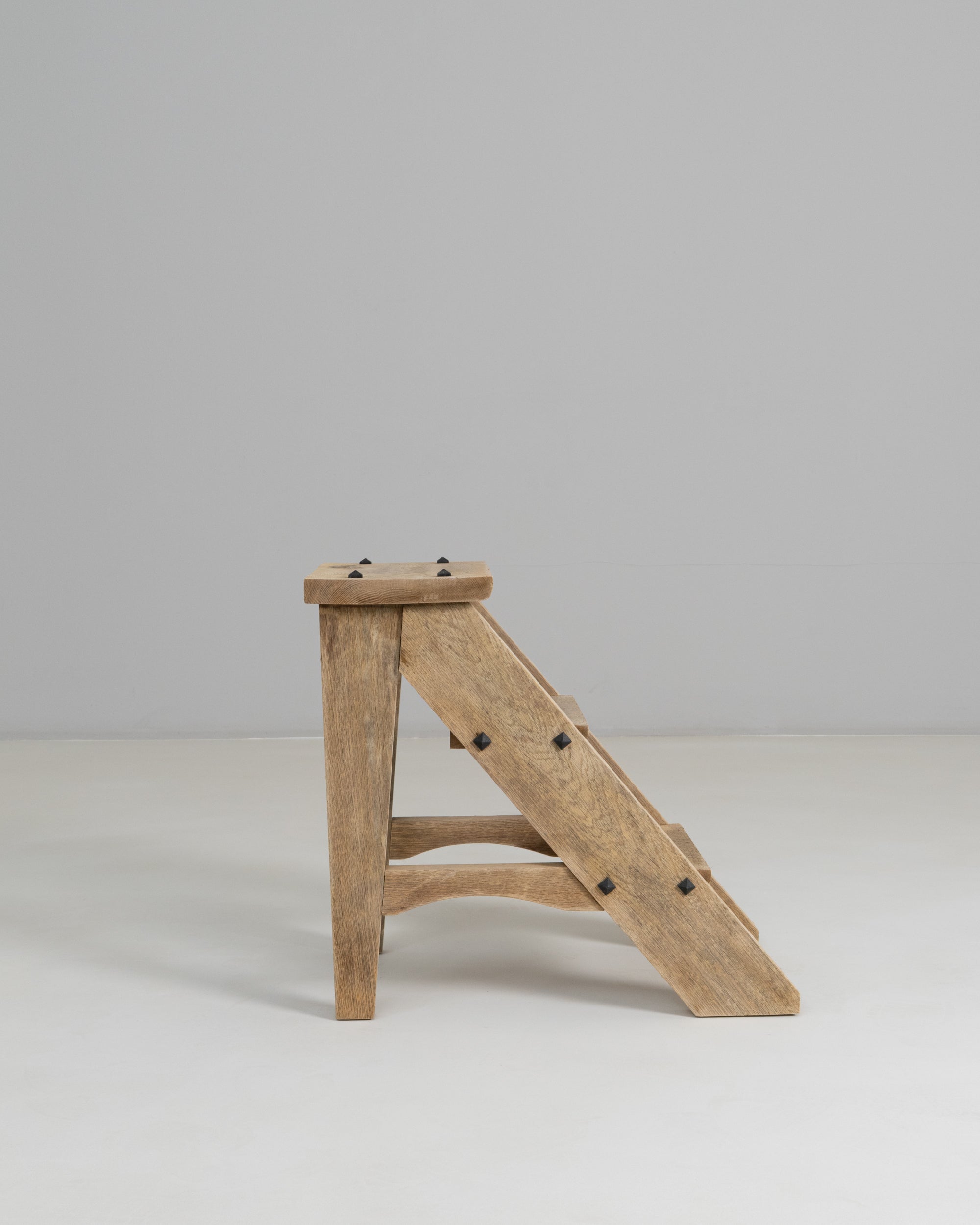 These 1970s French oak steps showcase a simple yet beautifully crafted design rooted in functional farmhouse tradition. Built from solid oak, the piece features clean lines, angled supports, and visible joinery that highlight its sturdy construction