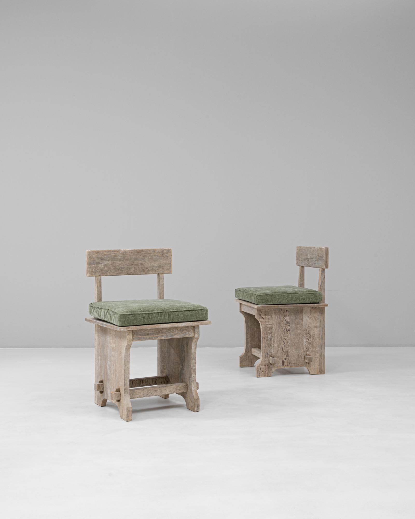 Questa coppia di sedie in rovere francese degli anni '70 presenta un design audace e scultoreo che fonde l'artigianato rustico con l'influenza modernista. Realizzata in rovere massiccio, ogni sedia presenta uno schienale quadrato, una robusta base