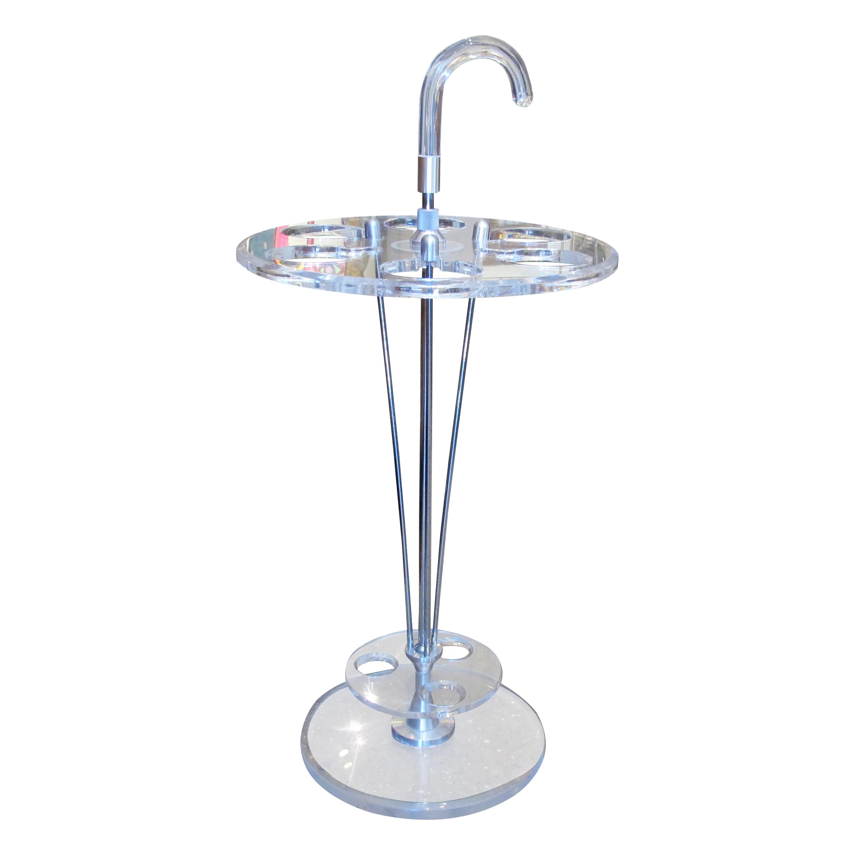 Elegante portaombrelli francese degli anni '70, realizzato in perspex trasparente/lucite con dettagli cromati. Il design è caratterizzato da quattro portaombrelli disposti intorno a un fusto centrale cromato con manico curvo, che unisce la praticità