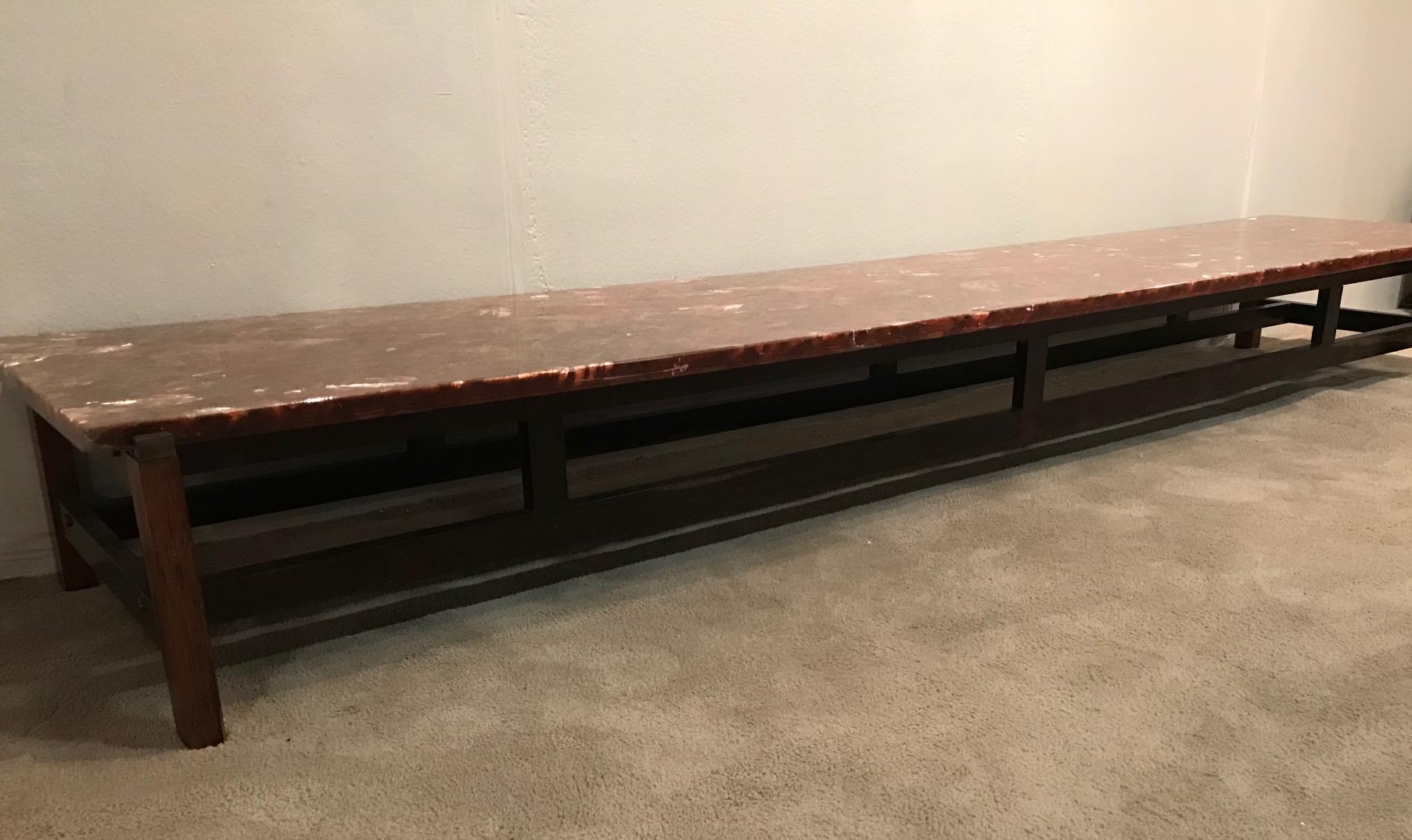 A stunning long coffee table French, circa 1970s. With a cast resin top and rosewood base, this table is extremely cool and elegant. It also features bronzed metal supports on the top of the legs, which hold the resin top in place.
 