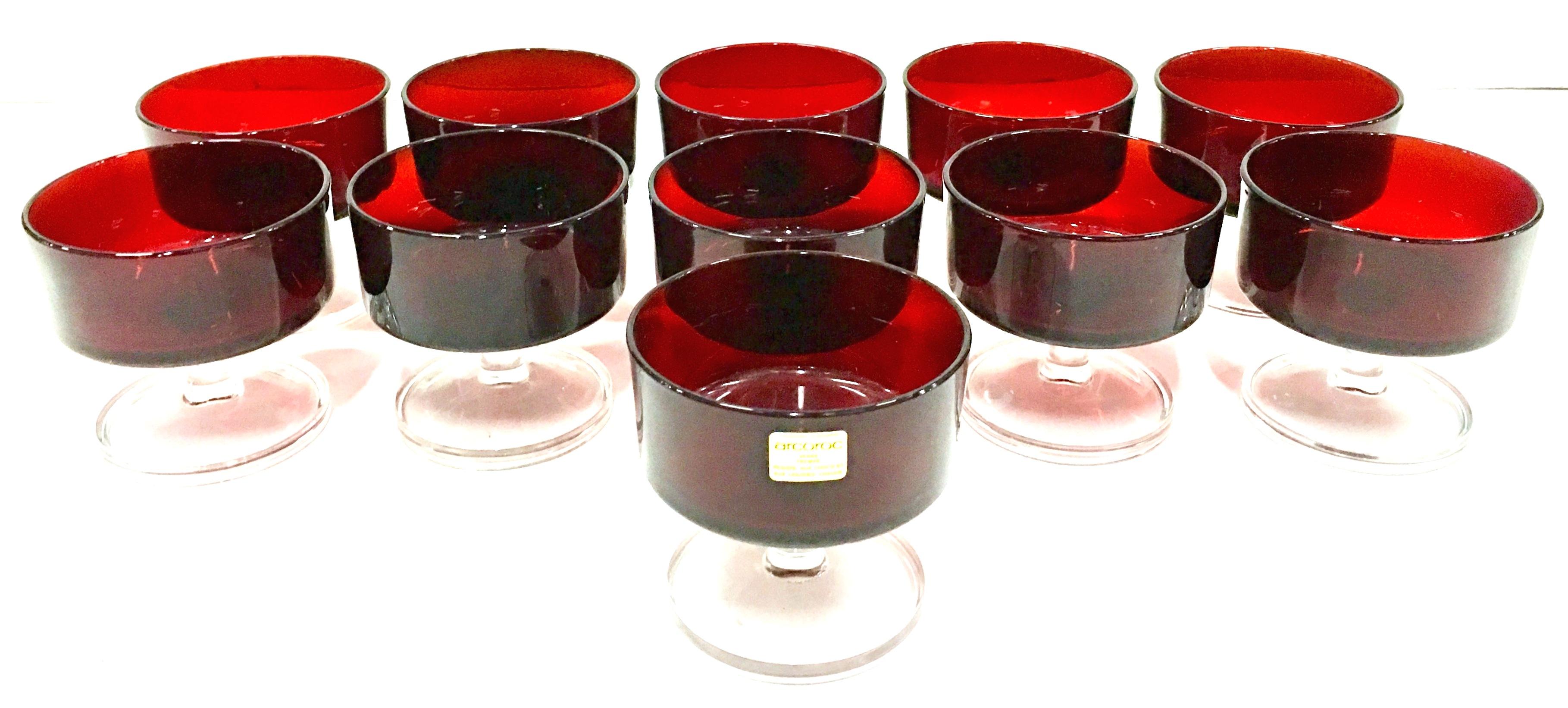 1970'S French ruby red and clear footed stem coveted coupe glasses by, Arcoroc. These glasses appear to be new and two of the eleven pieces maintain the original manufacturer sticker.