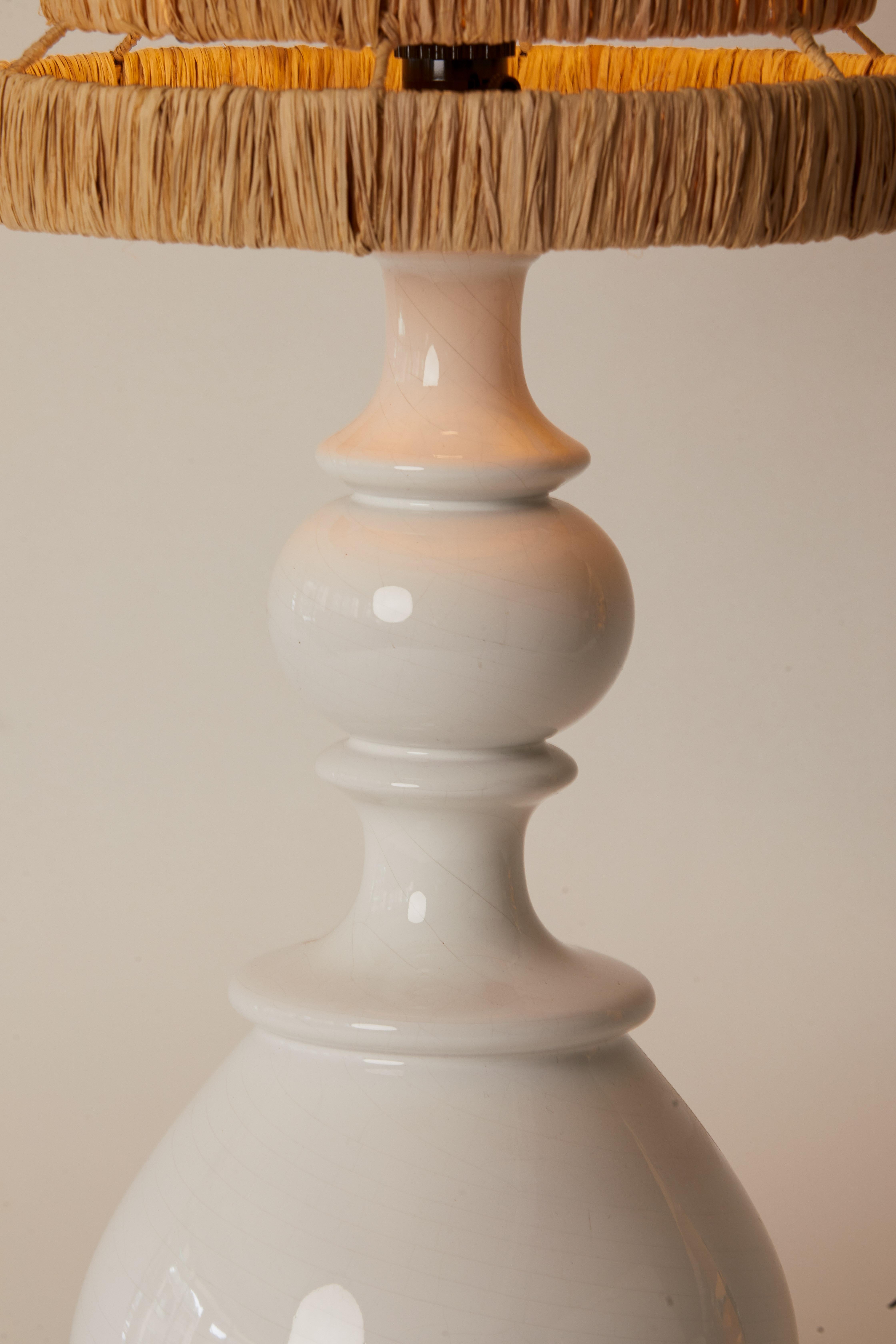1970s French white circular pottery lamp with brown raffia lampshade.