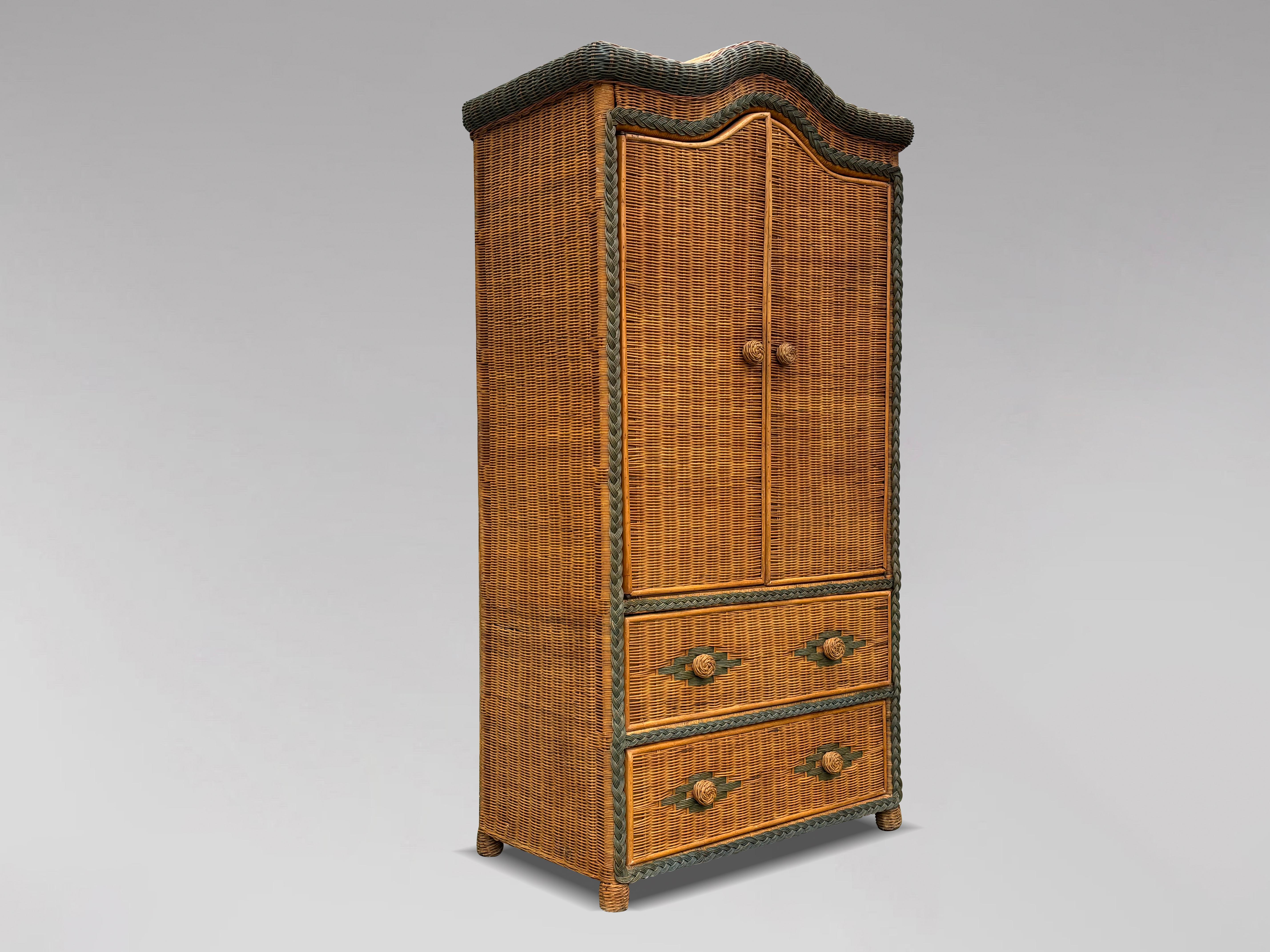 This charming mid-20th-century vintage woven wicker and bamboo wardrobe features two doors and two drawers, showcasing exquisite colouring and intricate detailing. Crafted from wicker, rattan and bamboo, this piece boasts a natural charm with woven