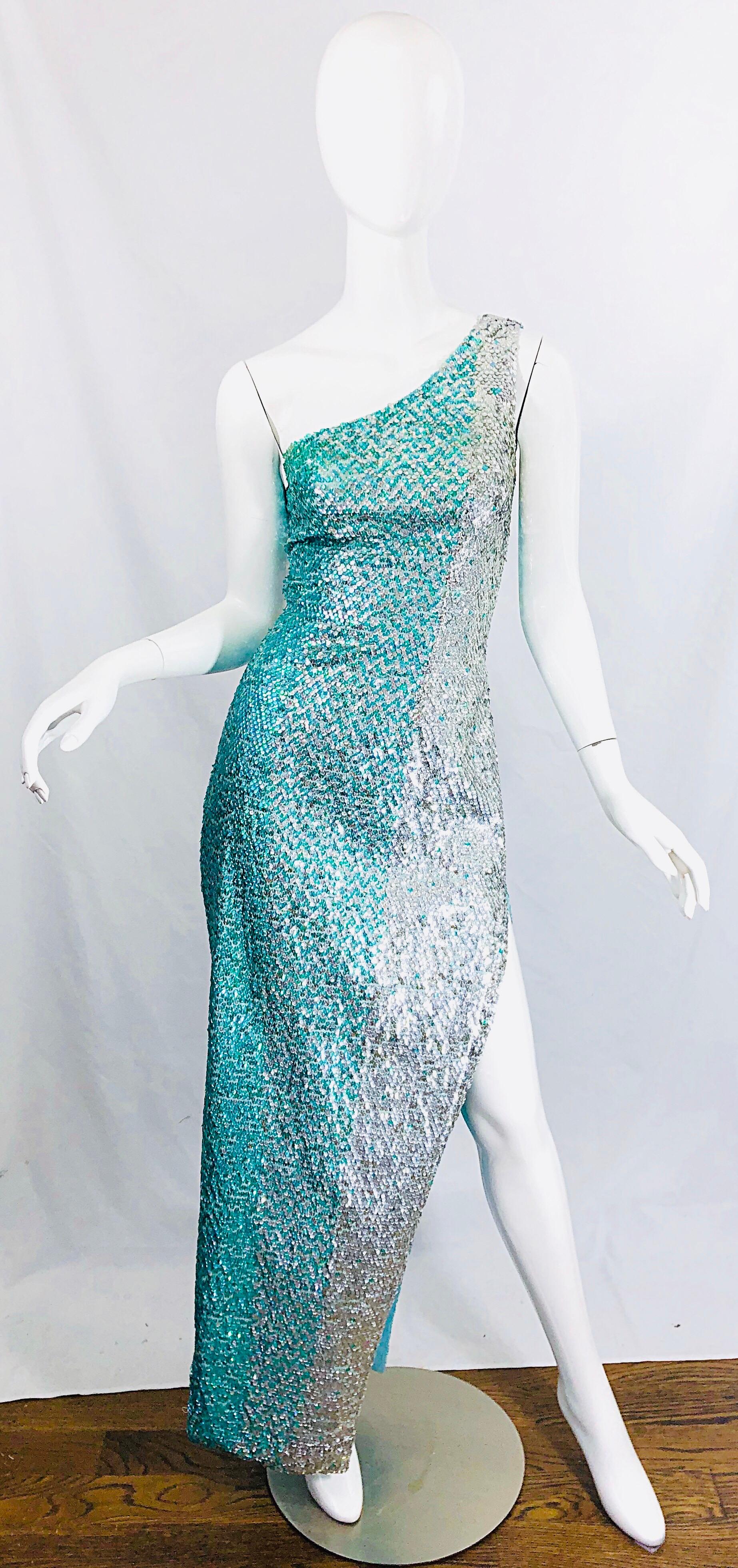 Sexy 1970s fully sequined turquoise blue and silver one shoulder gown ! Features thousands of hand-sewn sequins throughout the entire dress. Silver and aqua sequins throughout. Hidden zipper up the back with 
hook-and-eye closure. Slits up both legs