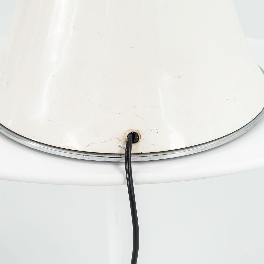 This is a Pipistrello Lamp, Model 620, designed by Gae Aulenti for Martinelli Luce in 1965. This example dates to the 1970s. It features an opal-white methacrylate shade, and the base and knob are white lacquered aluminum.‚Äé The lamp offers a