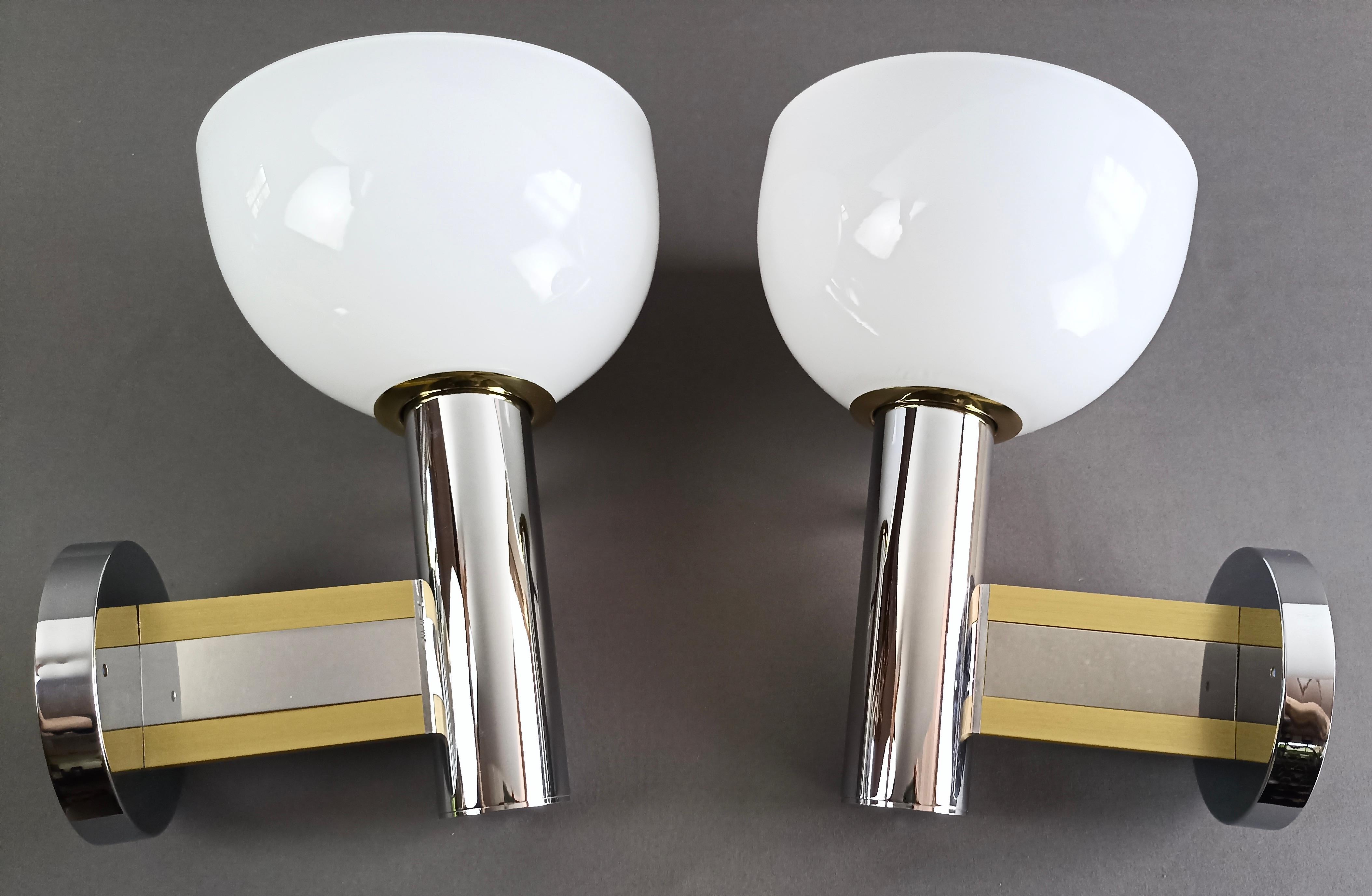 Beautiful and rare pair of wall lamps by Gaetano Sciolari, new and never used, coming directly from a old warehouse still packed in the original box.
The design of the chrome metal frame is very minimalist, with gilded aluminum and brass details.