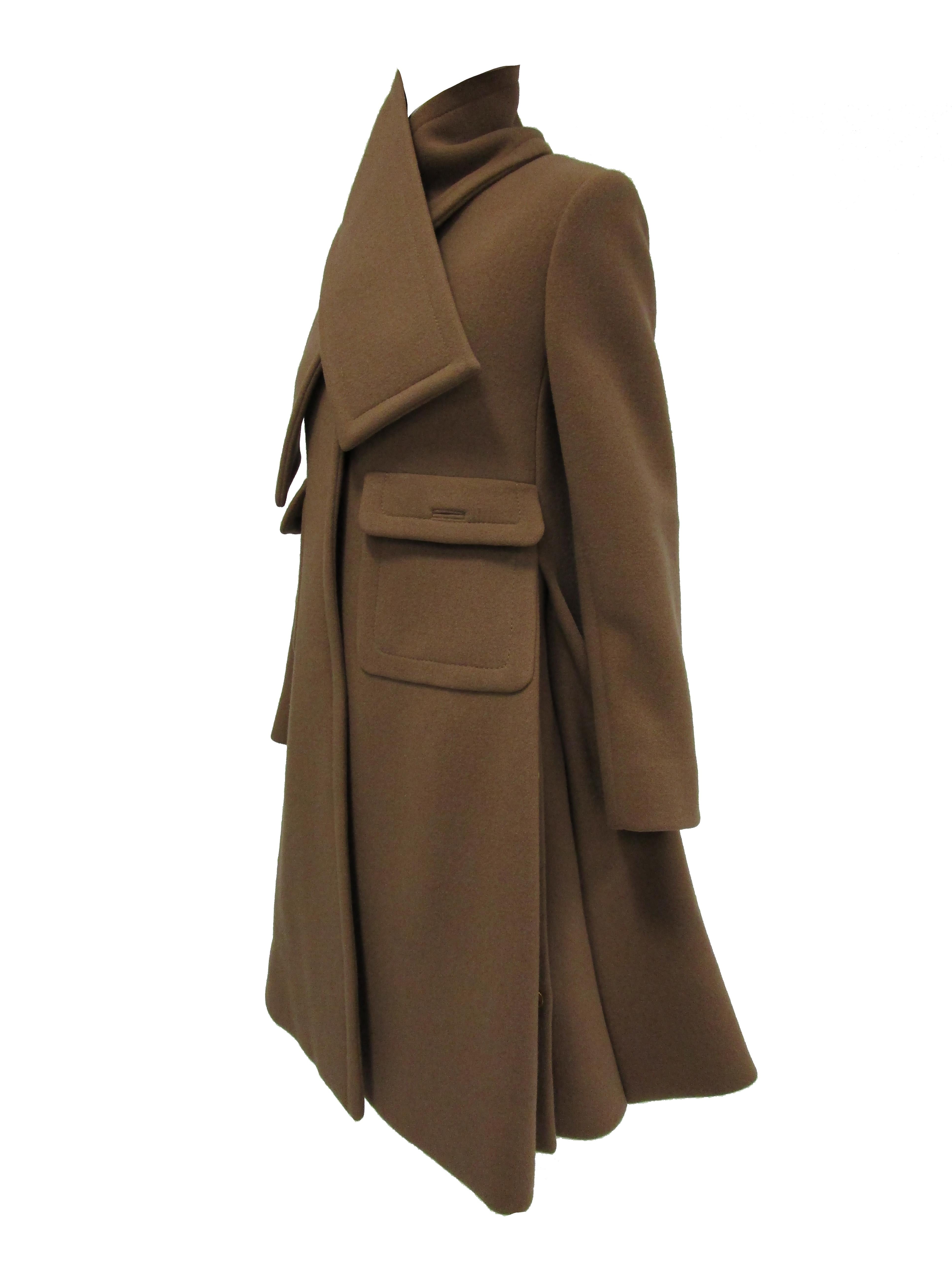 Gorgeous soft brown wool coat by Galanos. The coat hits just above the knee, has long sleeves, gently sloping shoulders, and a shallow V - neckline. The coat features two large pockets in front with flap and button closure. The coat has three