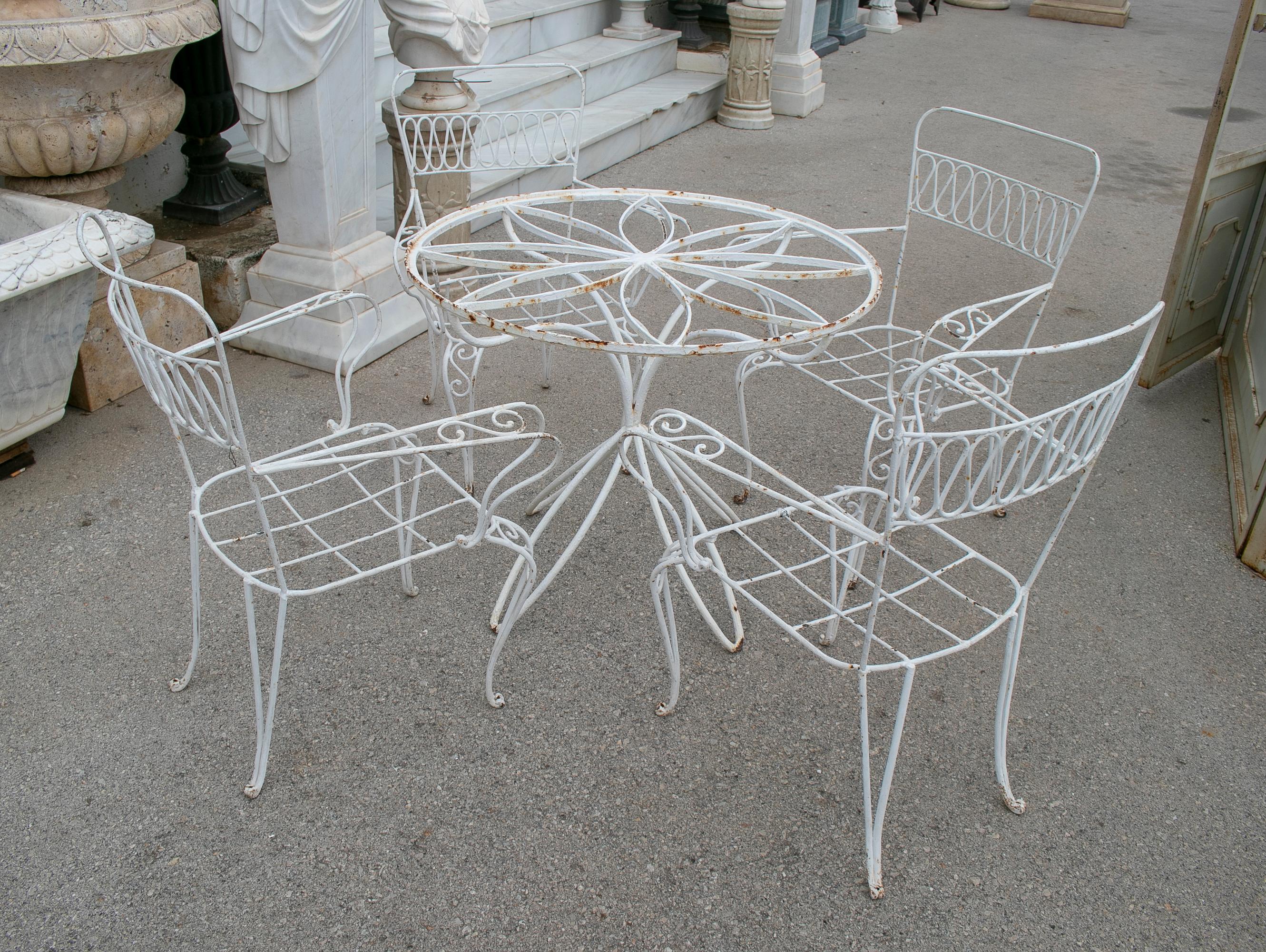1970s garden set of an iron circular table and four chairs. 

Table measurements: 71 x 86cm
Chair measurements: 88 x 69 x 56cm.