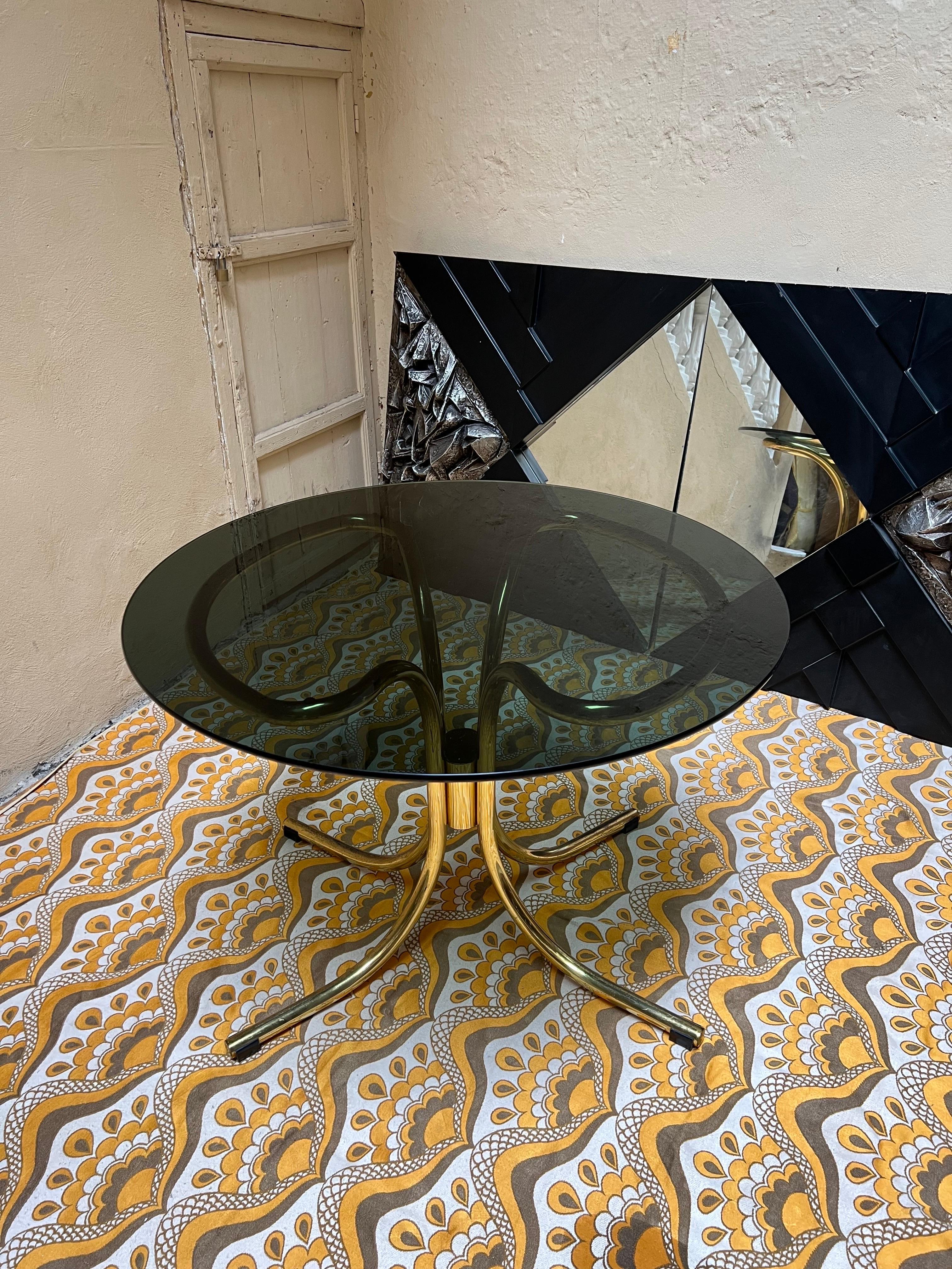 Gastone Rinaldi (1920-2006) for Cidue, dining room table. Its in gold coated chromed steel with fume glass top. Table construction with a base made of three curved elements made of chromed tubular steel and a round, thick-walled, loose tabletop.