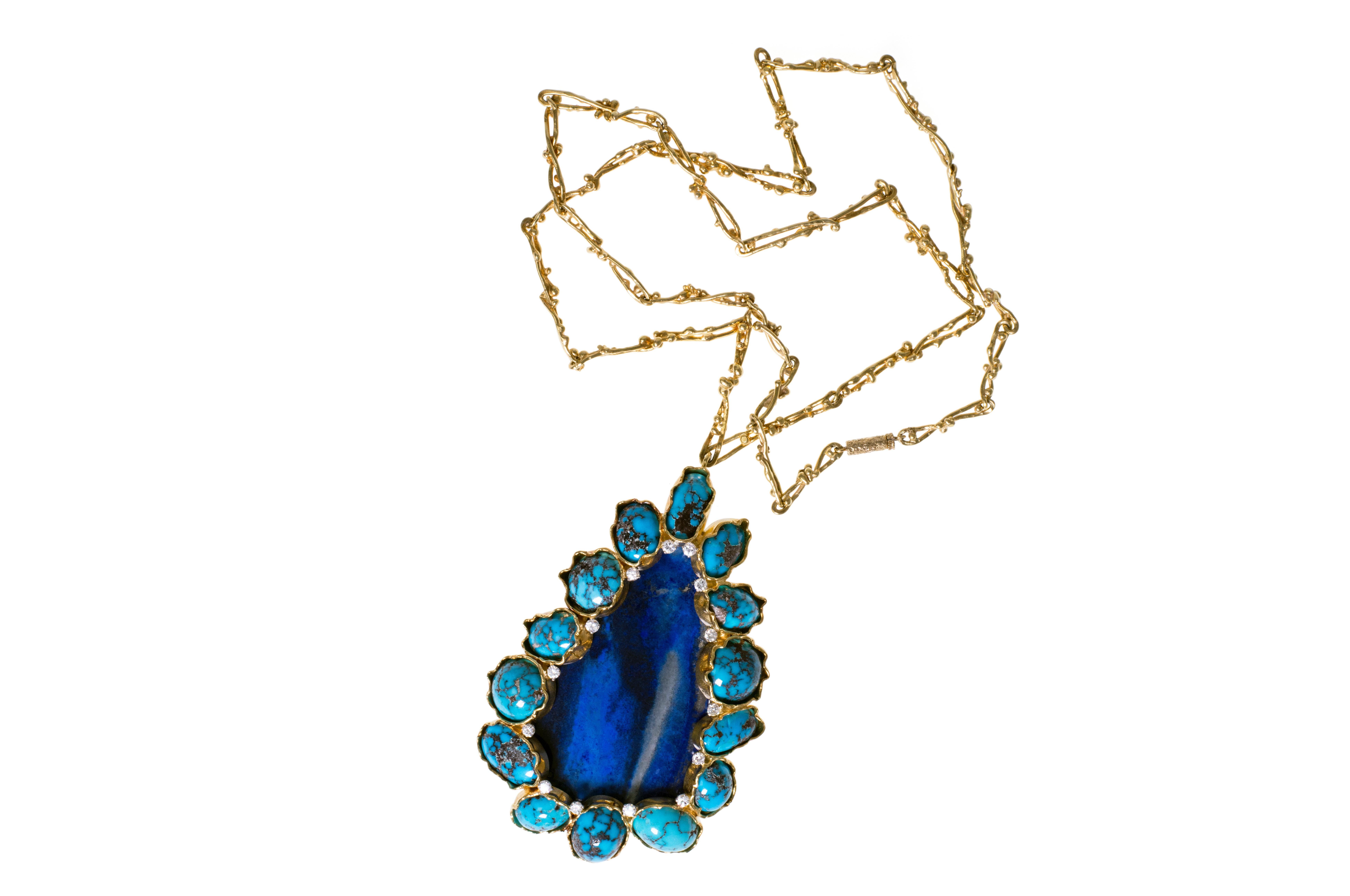 A lapis lazuli, cabochon turquoise, diamond and 18 karat gold pendant, on an 18 karat gold link chain, by British designer George Weil, c. 1970. The necklace is stamped G. Weil, 18K, PLAT. 
The pendant measures 3.75