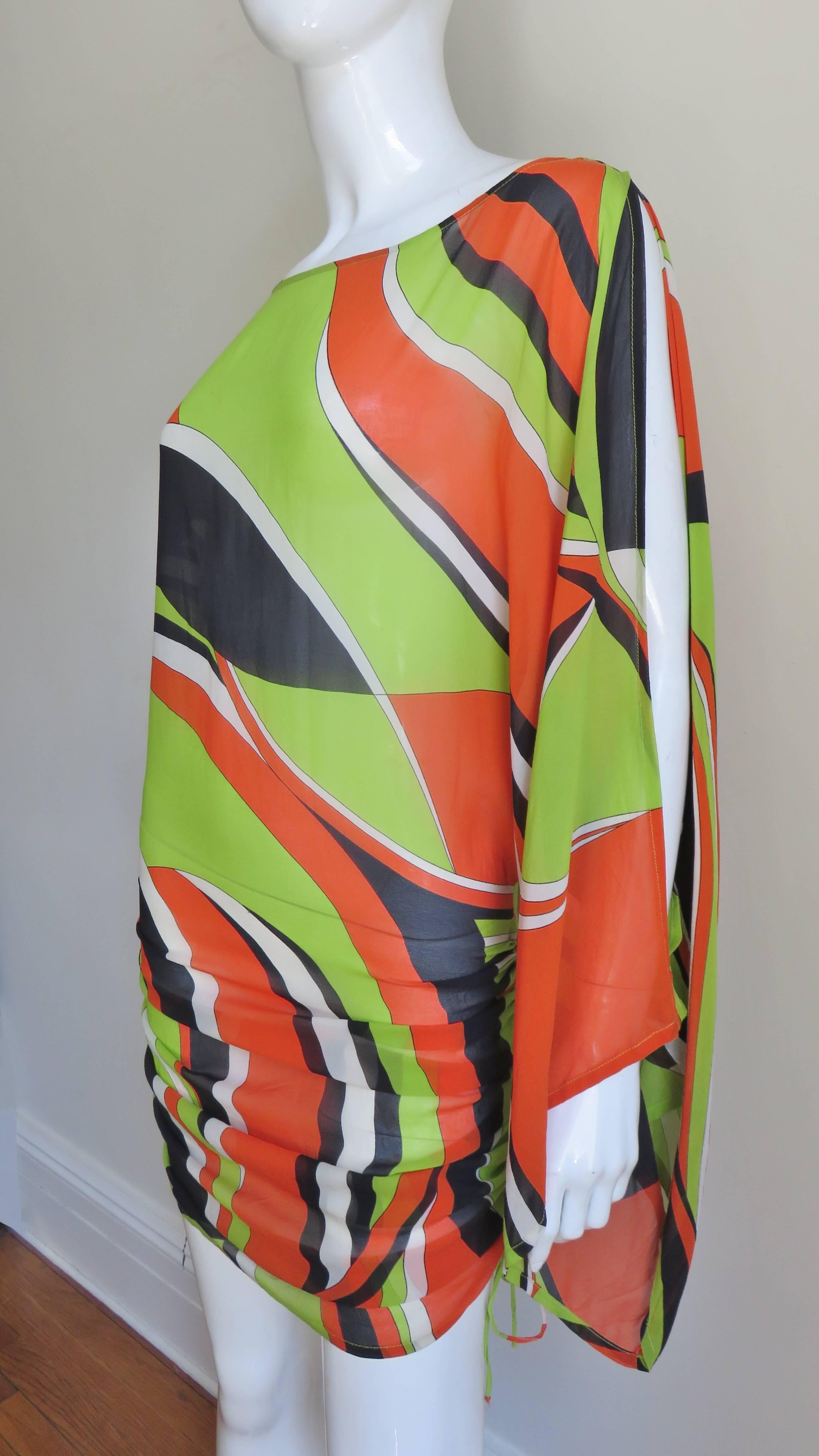 A fabulous silk print dress from French designer Georges Rech in green, orange, black, and white. It has long full kimono sleeves open from the shoulders to the wrists on the outside.  The bodice portion is blouson draping over a straight skirt with