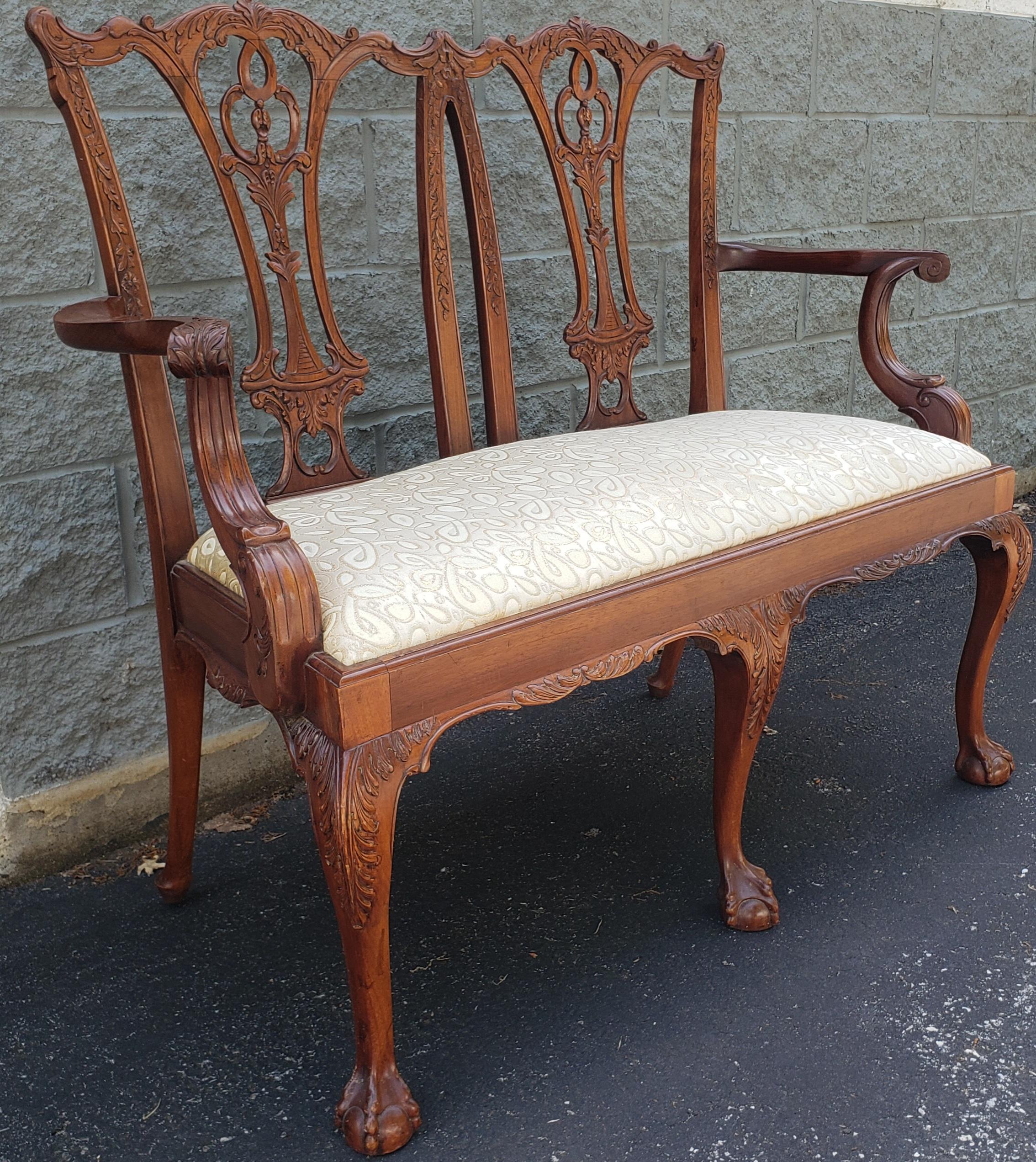 An intricately high quality crafted and hand carved Chippendale style mahogany settee with ball claw feet in good vintage condition.
The High quality upholstery is clean. Measures 47.5
