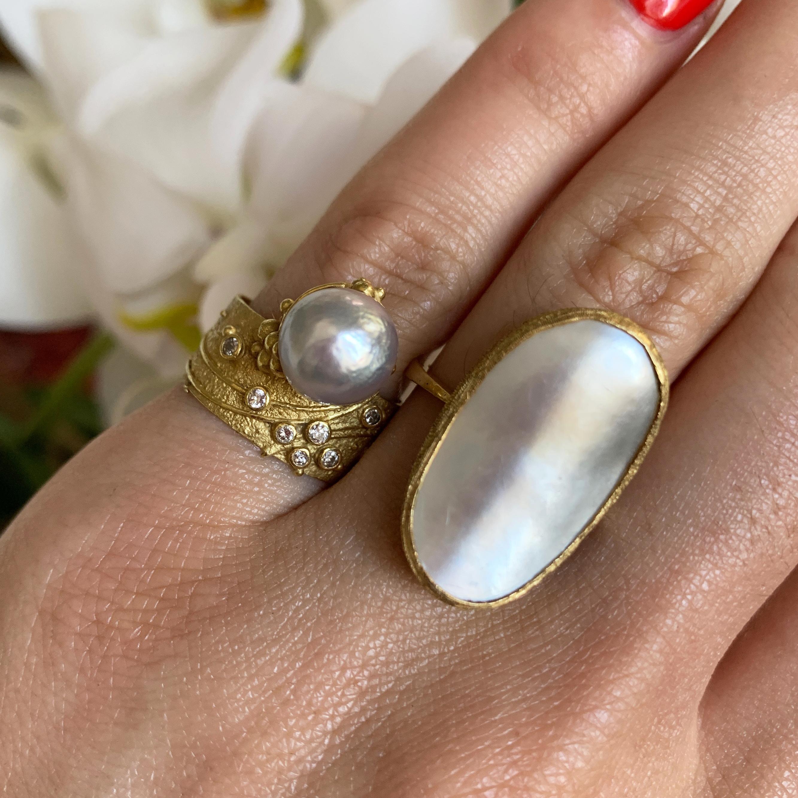 A vintage handmade and unique pearl, diamond and textured 18 karat yellow gold ring, by Gerda Flöckinger, United Kingdom, c. 1970. Signed GF. Ring is a size 6.25 and measures 0.70