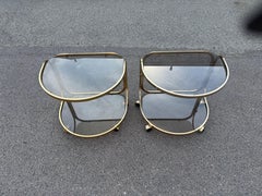 1970's German brass rollable nightstands, with toned glass shelves
