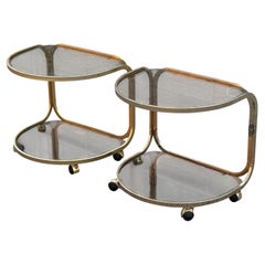 1970's German brass rollable nightstands, with toned glass shelves