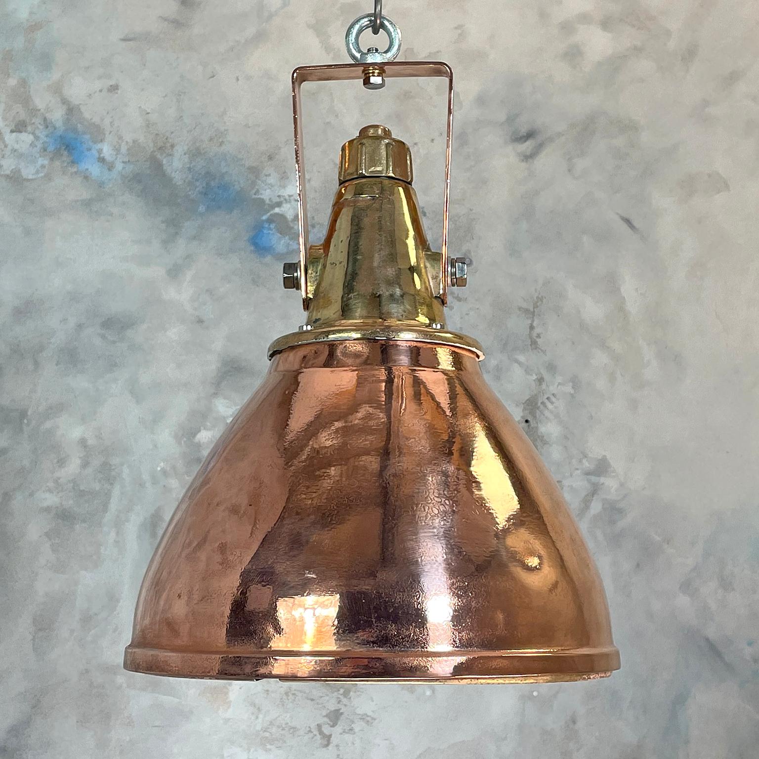 A copper and brass ceiling pendant light made in Germany in the 1970s originally for industrial use on cargo ships and sea going vessels.

The dome is made from spun brass with a cast brass top, behind the glass there is an aluminium reflector to