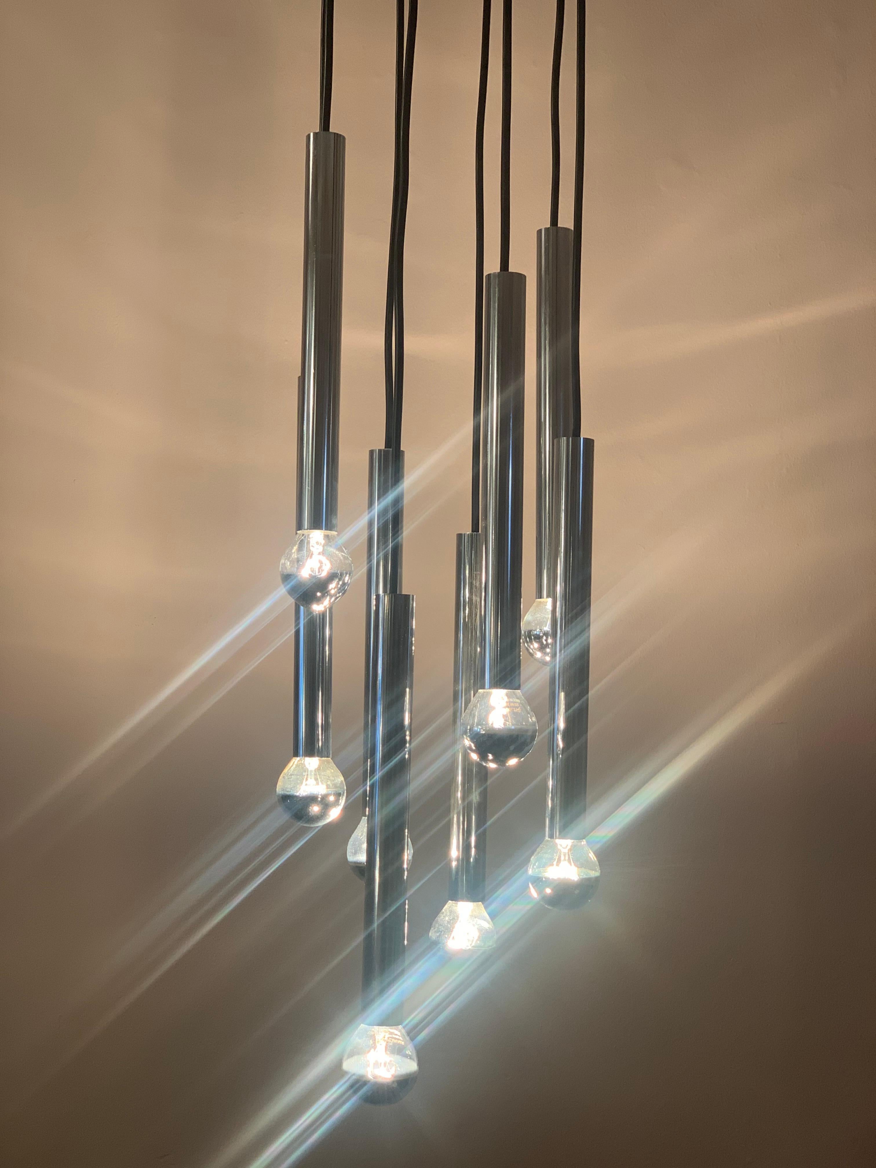 1970s German Doria Leuchten, cascading, hanging, ceiling light with 8 chrome tubes suspended from black wire from a circular ceiling plate. A single E14 screw in bulb is required at the end of each tube preferably one with a silver cap which are