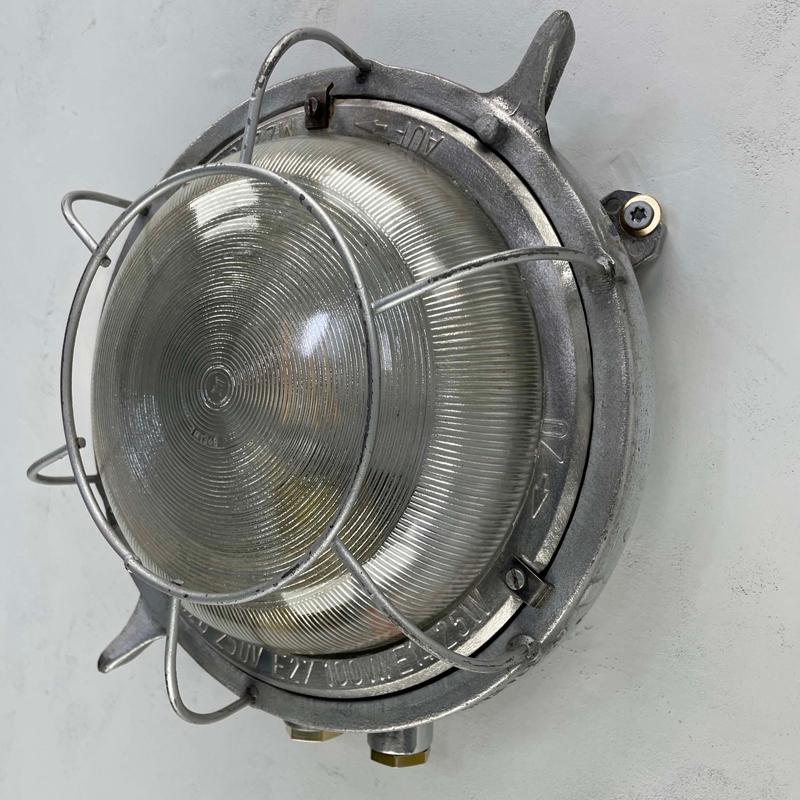 A retro industrial cast aluminium bulkhead or ceiling light with diffusion glass, made in GDR by EOW in the 1970's.

Specifications.
Diameter: 30cm
Depth: 12.5cm
Weight: 2.5kg
Bulb: E27 100w max

This is the largest wall light we sell with
