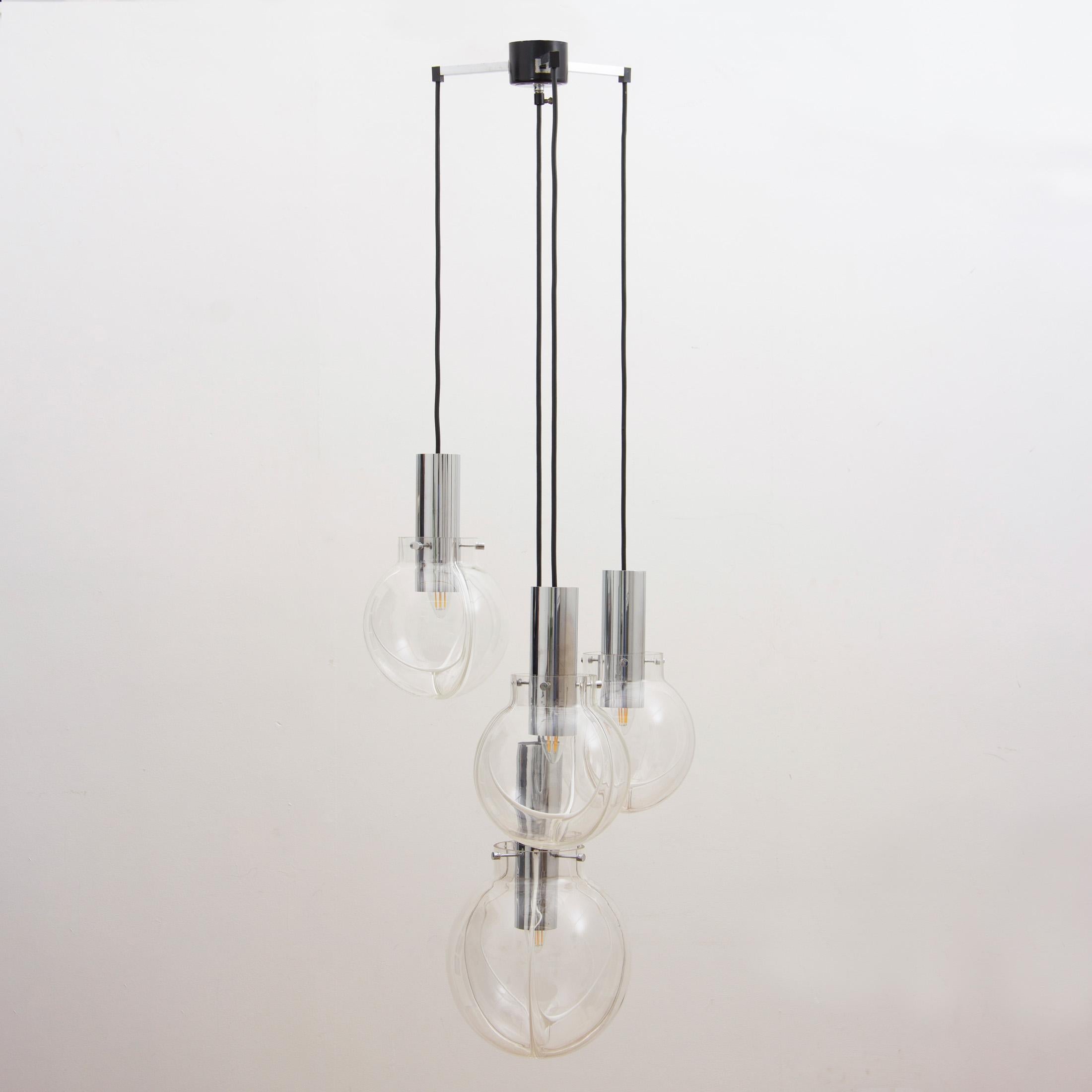 An usual and striking 1970s German clear and white glass hanging light with four cascading globes. Each globe features an unusual internal white glass ridge which the light reflects off to create a warm and soft glow. The lowest hanging globe is
