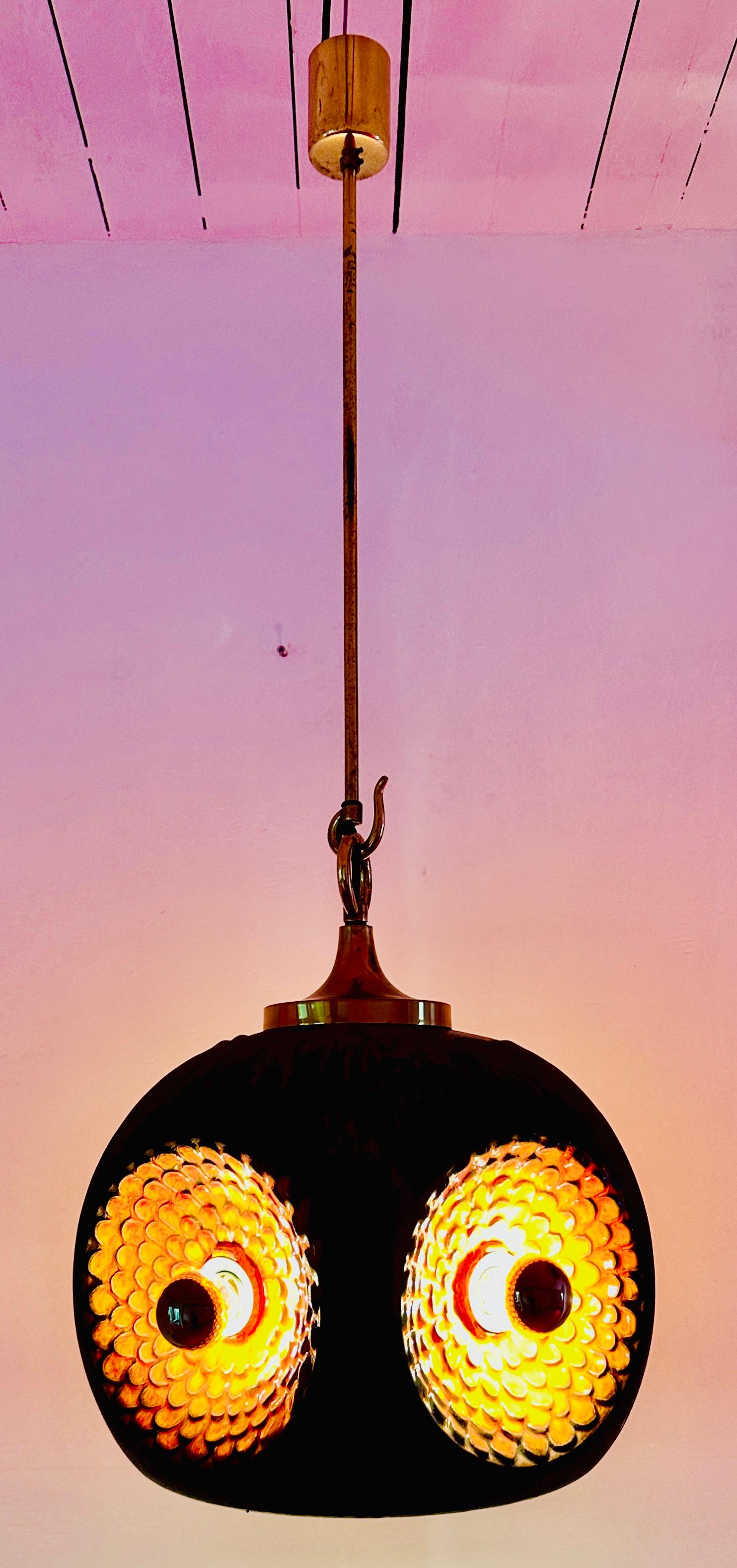 An unusual German glazed ceramic pendant hanging light in the Fat Lava style.  The four outer lightbulbs are set in the centre of an irridescent orange glazed concave circular flower petal 3-D design with the outer body a mottled brown matt colour. 