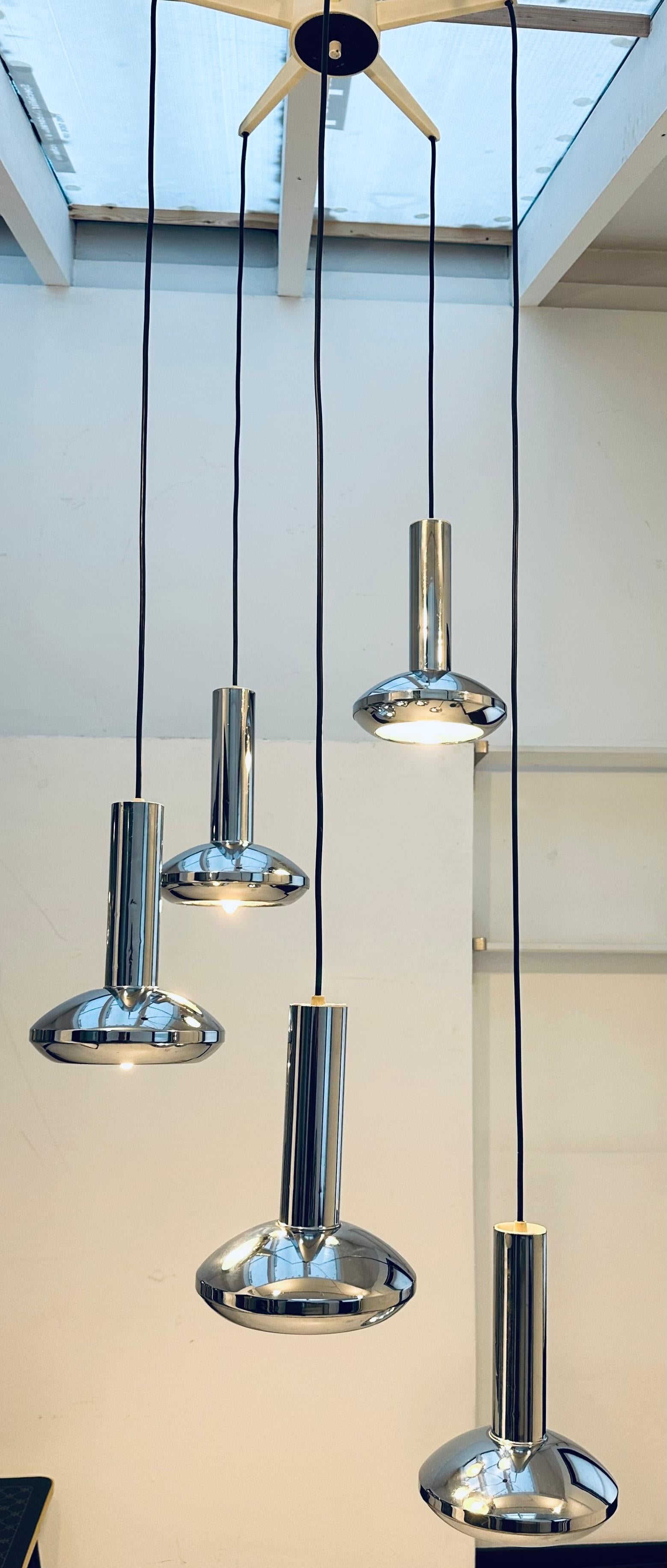1970s Space Age, UFO shaped, German hanging ceiling light with five cascading chrome shades each suspended on a black flex.  Manufactured by Hansel Leuchten in Germany.  The globes hang from a five pointed white plastic star ceiling holder which