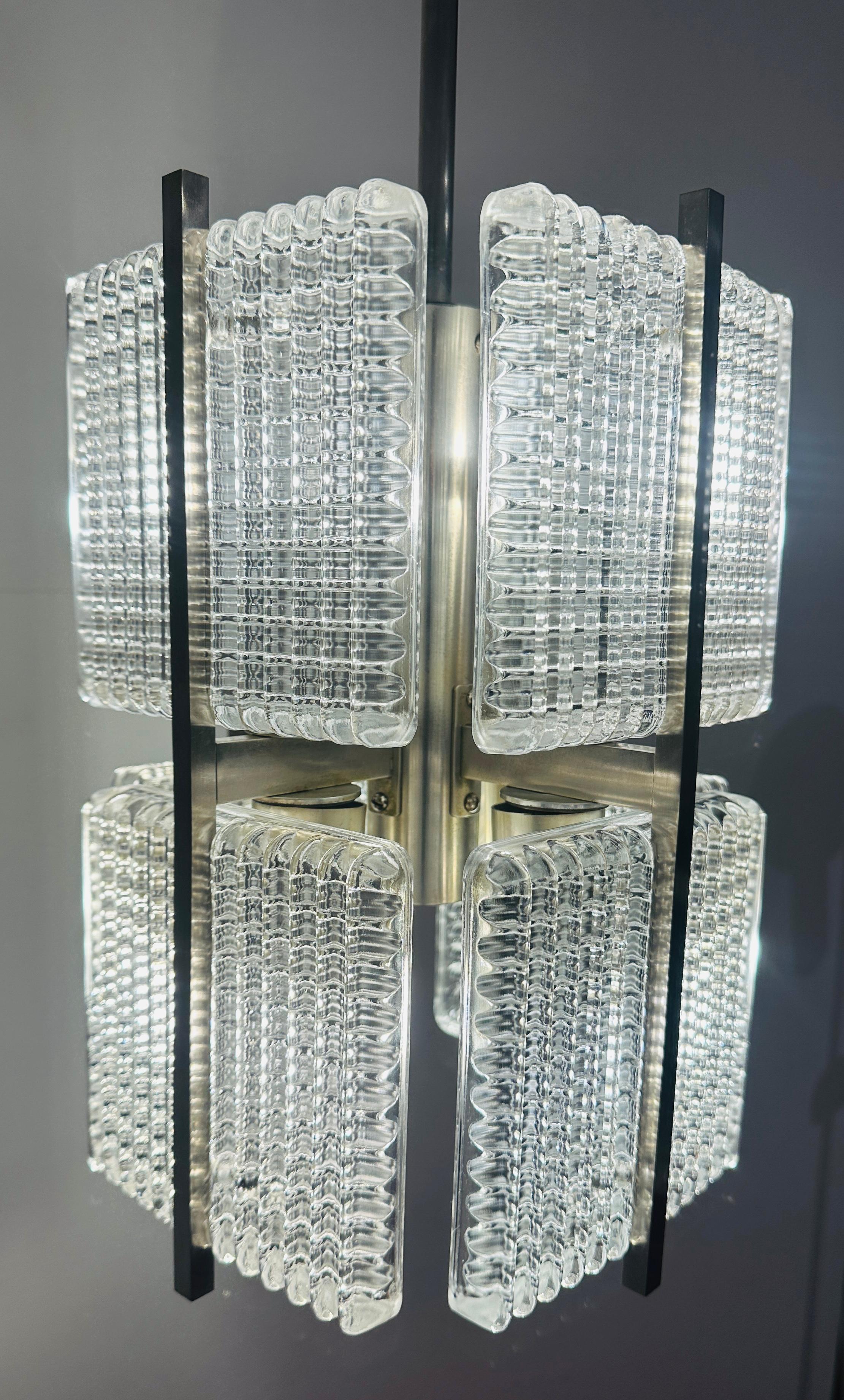 Una plafoniera a sospensione di ottima fattura, minimalista ed elegante, in vetro quadrato tedesco degli anni '70 e cromo spazzolato. Nello stile di Kaiser Leuchten.  Dopo molte ricerche non sono riuscito ad ottenere la sua provenienza.  Otto pezzi