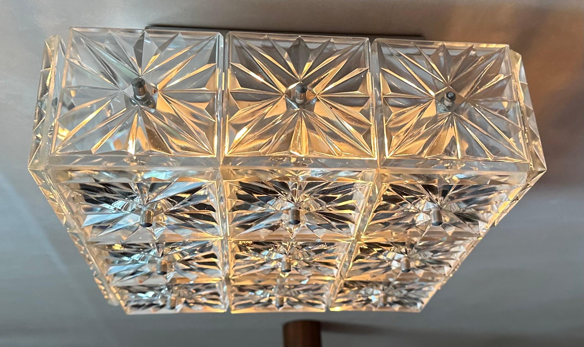 Plafoniera tedesca da incasso degli anni '70 con struttura in metallo grigio e 21 elementi quadrati in vetro prismatico sfaccettato.  Prodotto da Kinkeldey in Germania.  Gli elementi quadrati in vetro sono fissati al telaio con viti rotonde in cromo