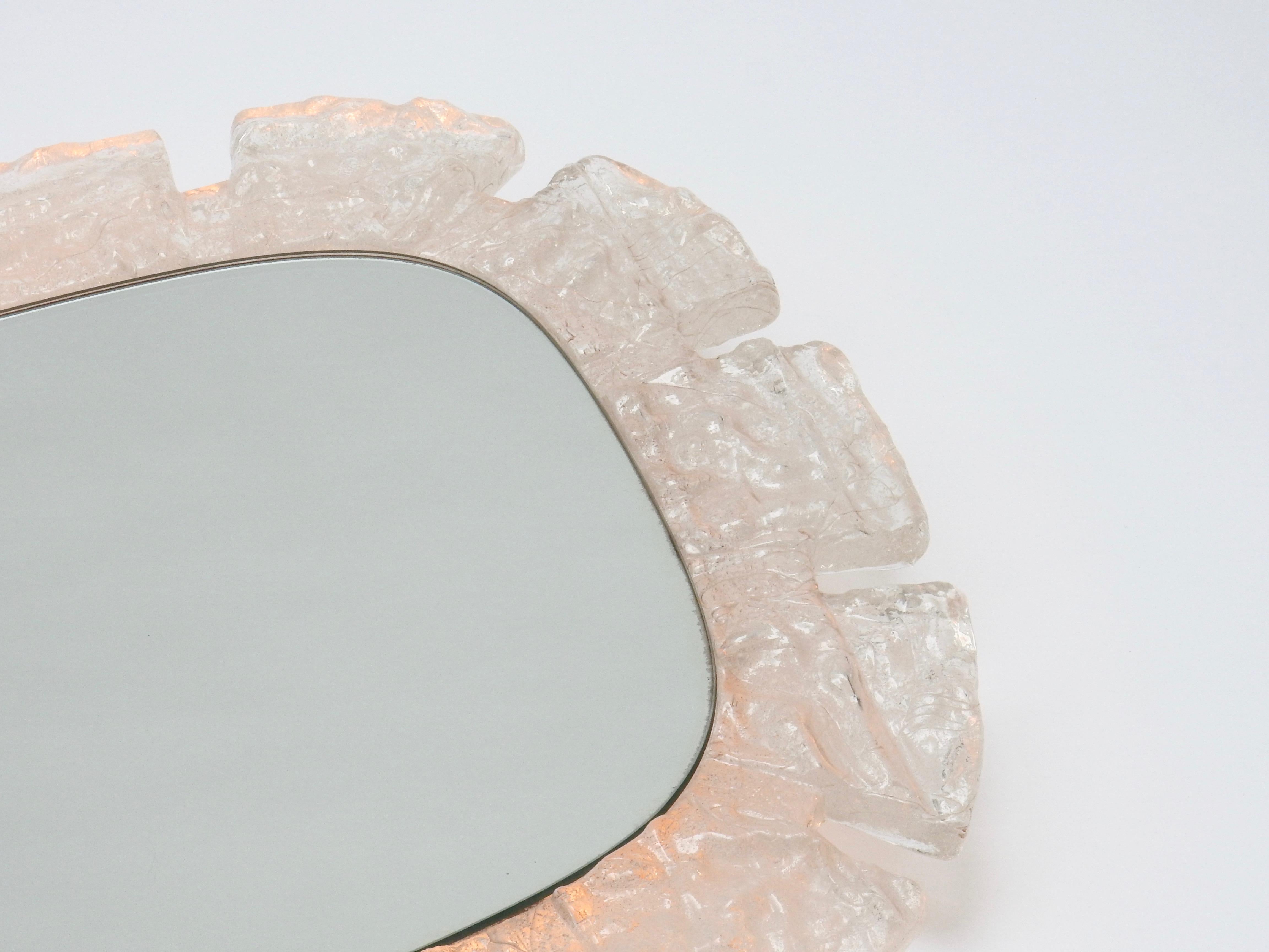 1970s German Lucite wall mirror and light. The mirror is surrounded by a frosted frame.