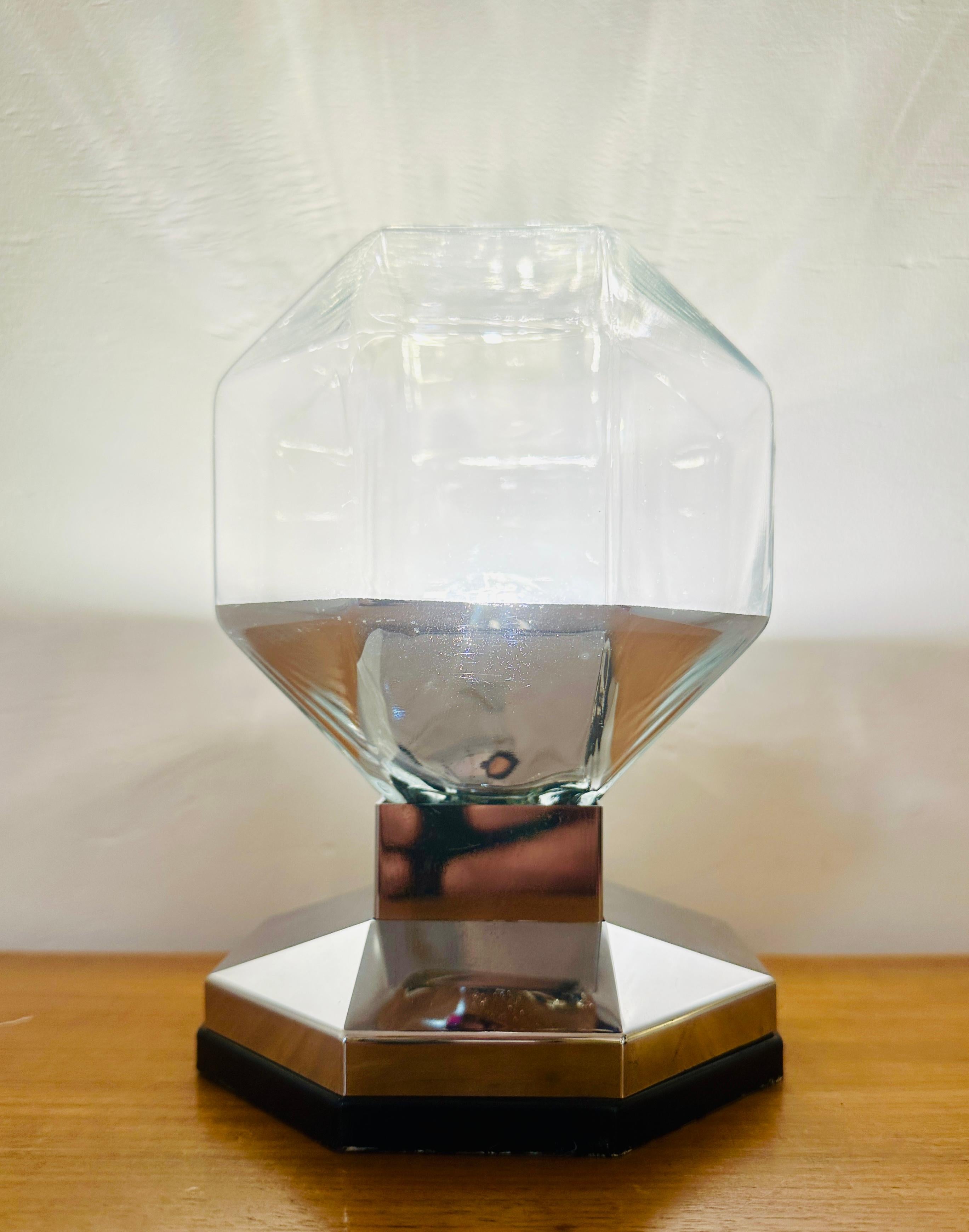 I am listing this wall light (also listed separately under wall lights) as a table lamp because I think it works well as both.  Designed by Motoko Ishii for Staff Leuchten during the 1970s in Germany. The hexagonal clear glass shade is coated silver