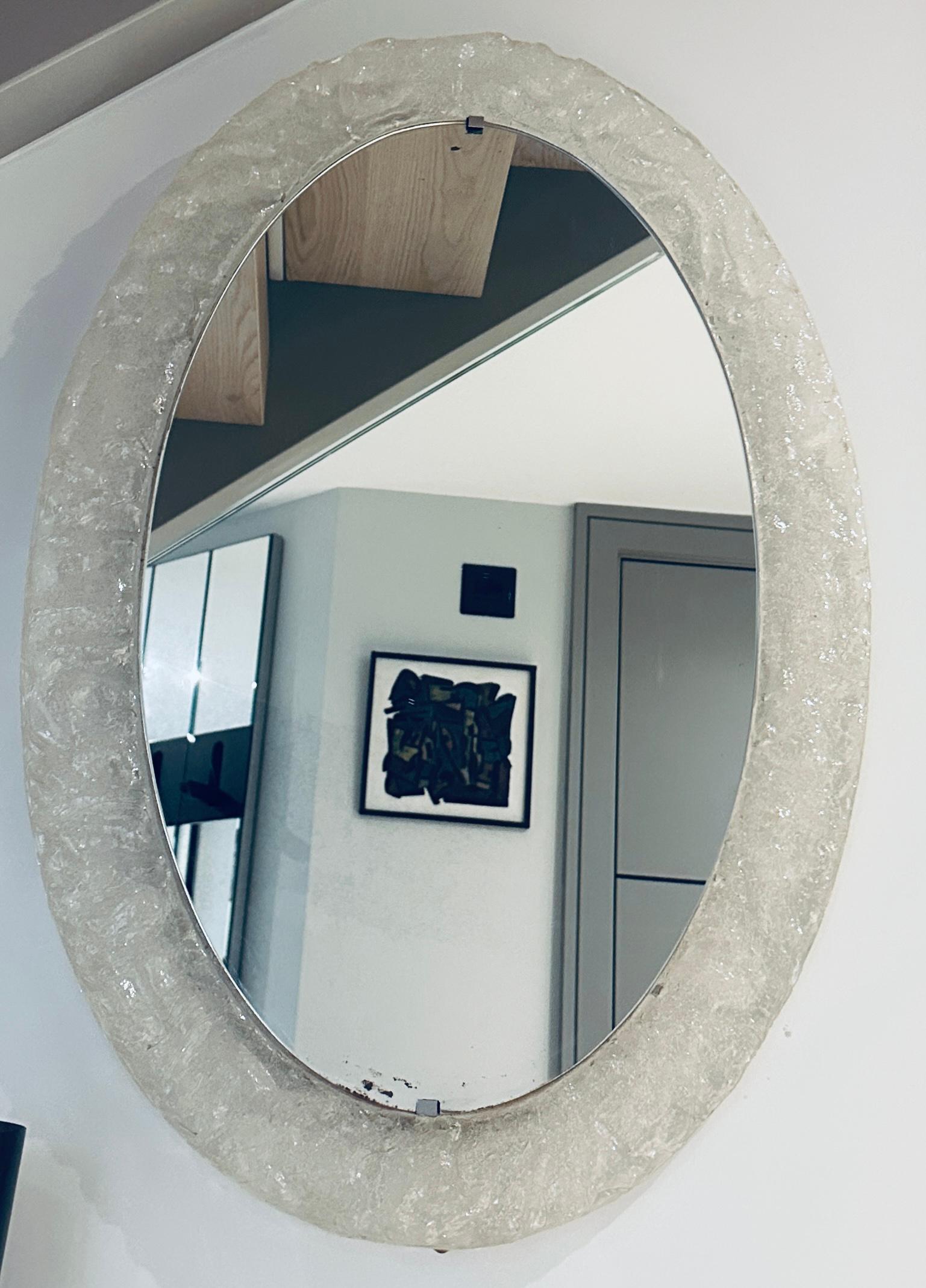 1970s German frosted iced effect acrylic framed oval wall mirror.   The mirror clips onto the frame at the top and bottom.  As shown in one of the images the edge shows a small area of age related wear and there are two very small scratches. 