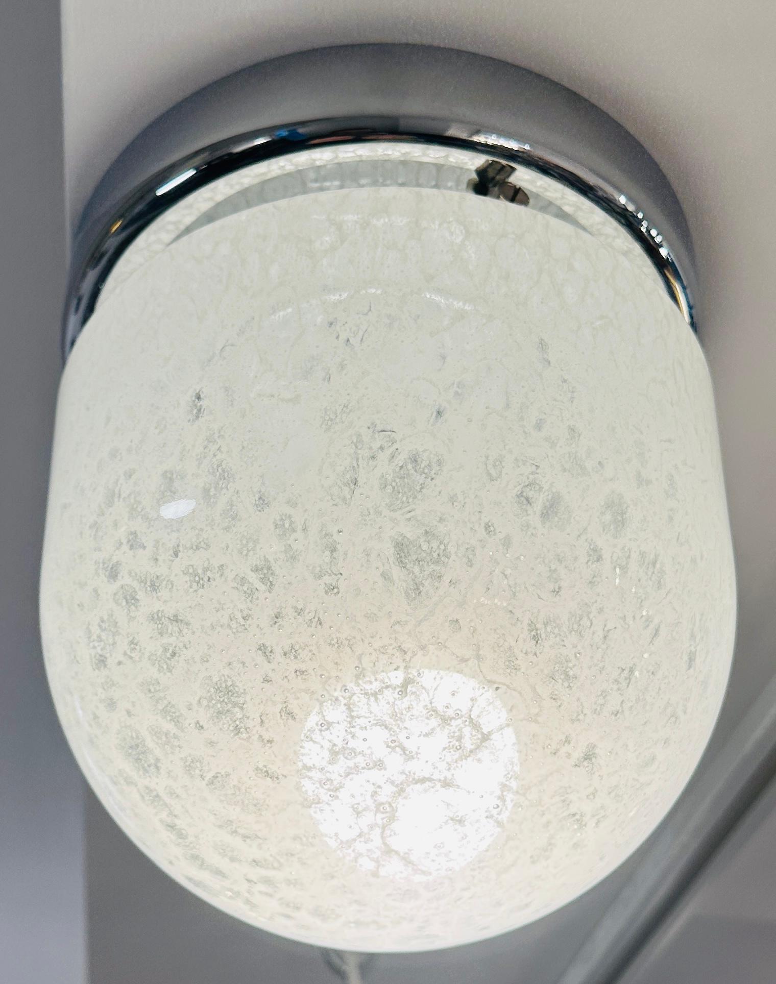 Plafond encastré en verre blanc marbré et chrome de la marque allemande Peill & Putzler, datant des années 1970.  Le plafonnier en métal chromé se visse au plafond et l'abat-jour en verre bombé y est fixé par trois vis intercalées qui le