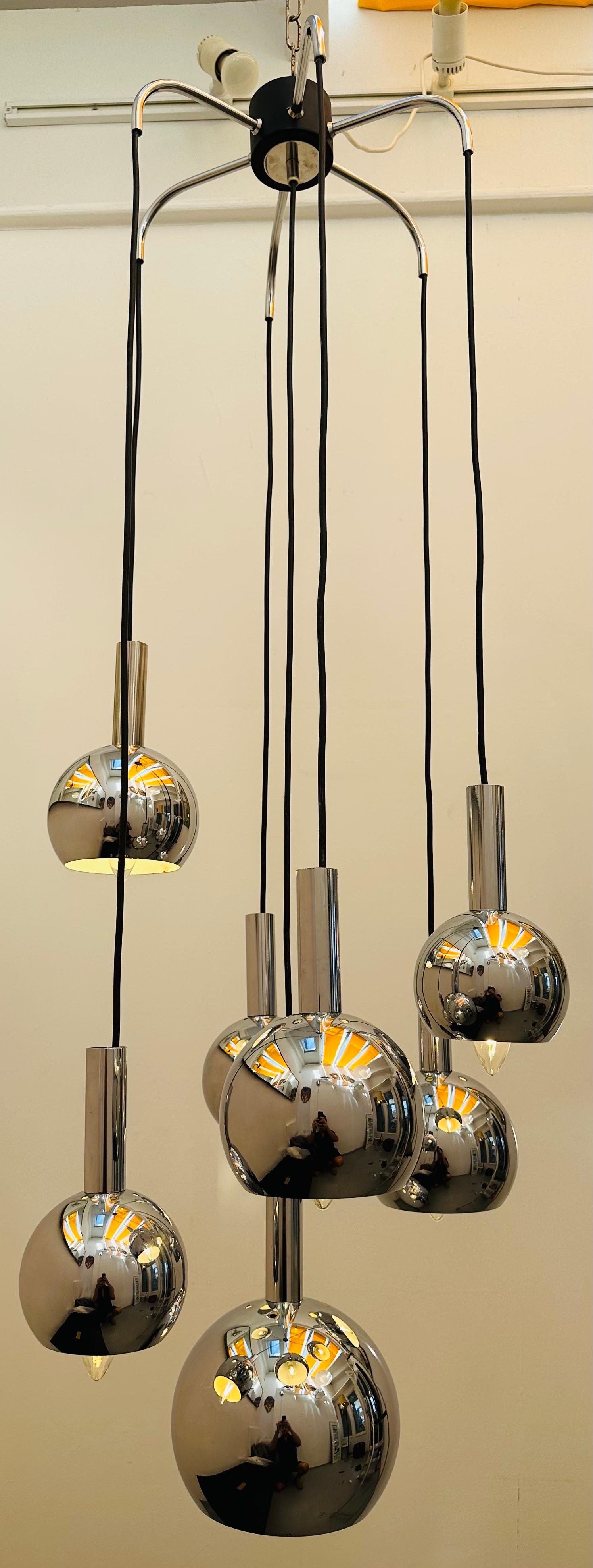 1970s German hanging ceiling light with seven cascading chrome ball-globes suspended from a black wire flex.  Manufactured by Ernest Plange for Plange Leuchten - the manufacturer's label is present in the star shaped ceiling holder.  The globes hang